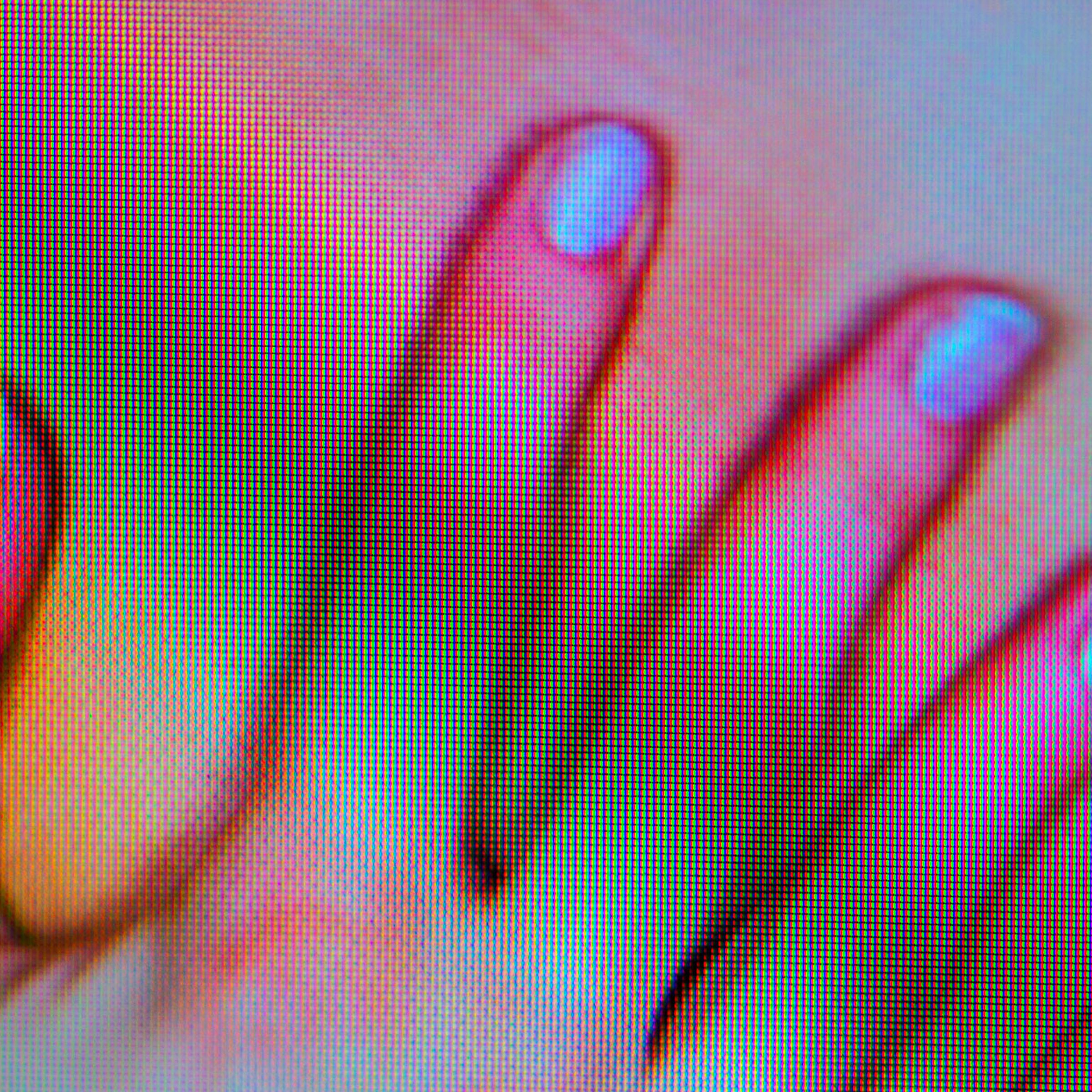 Blurry screenshot of a female hand touching her skin on a device.