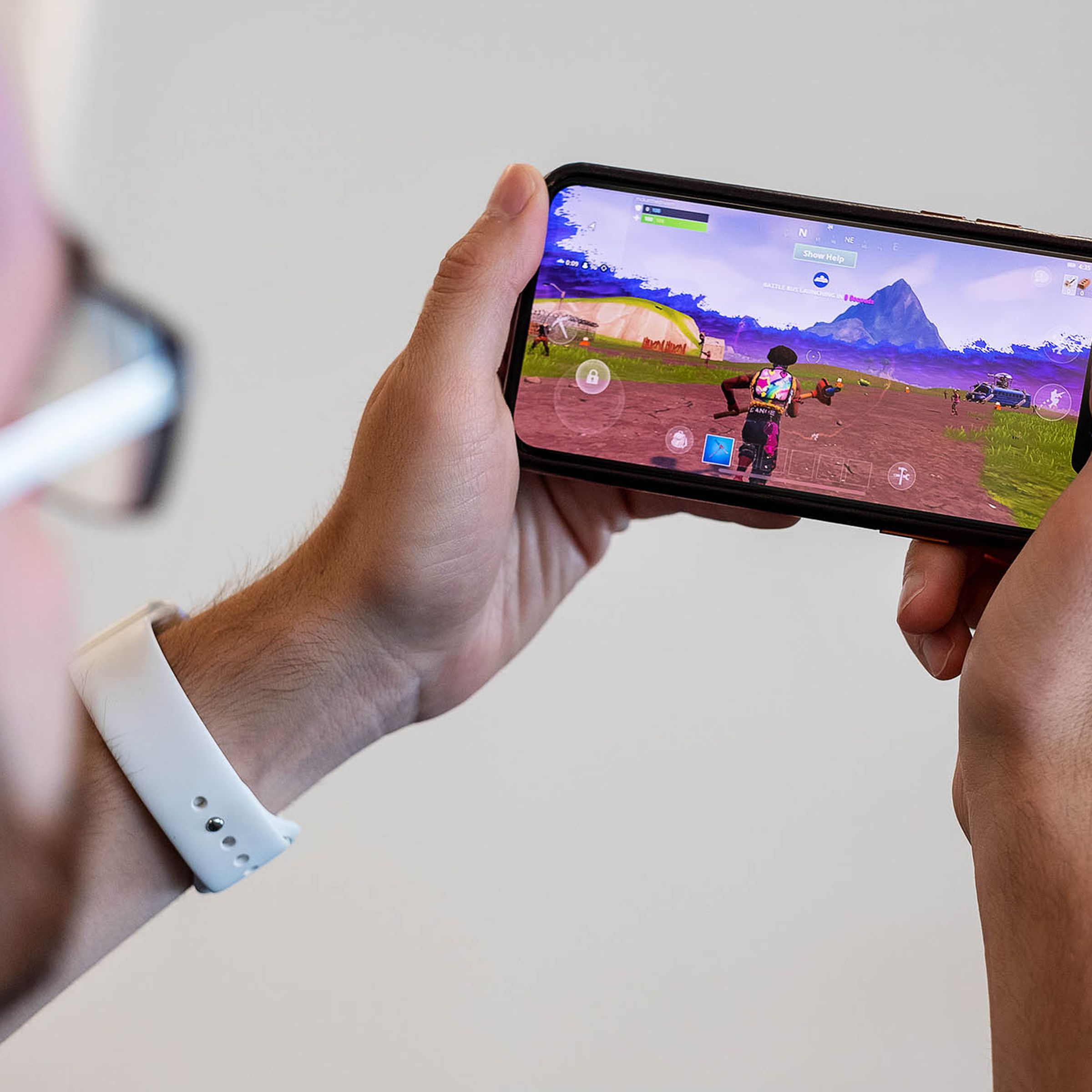 A person holding a phone playing Fortnite.
