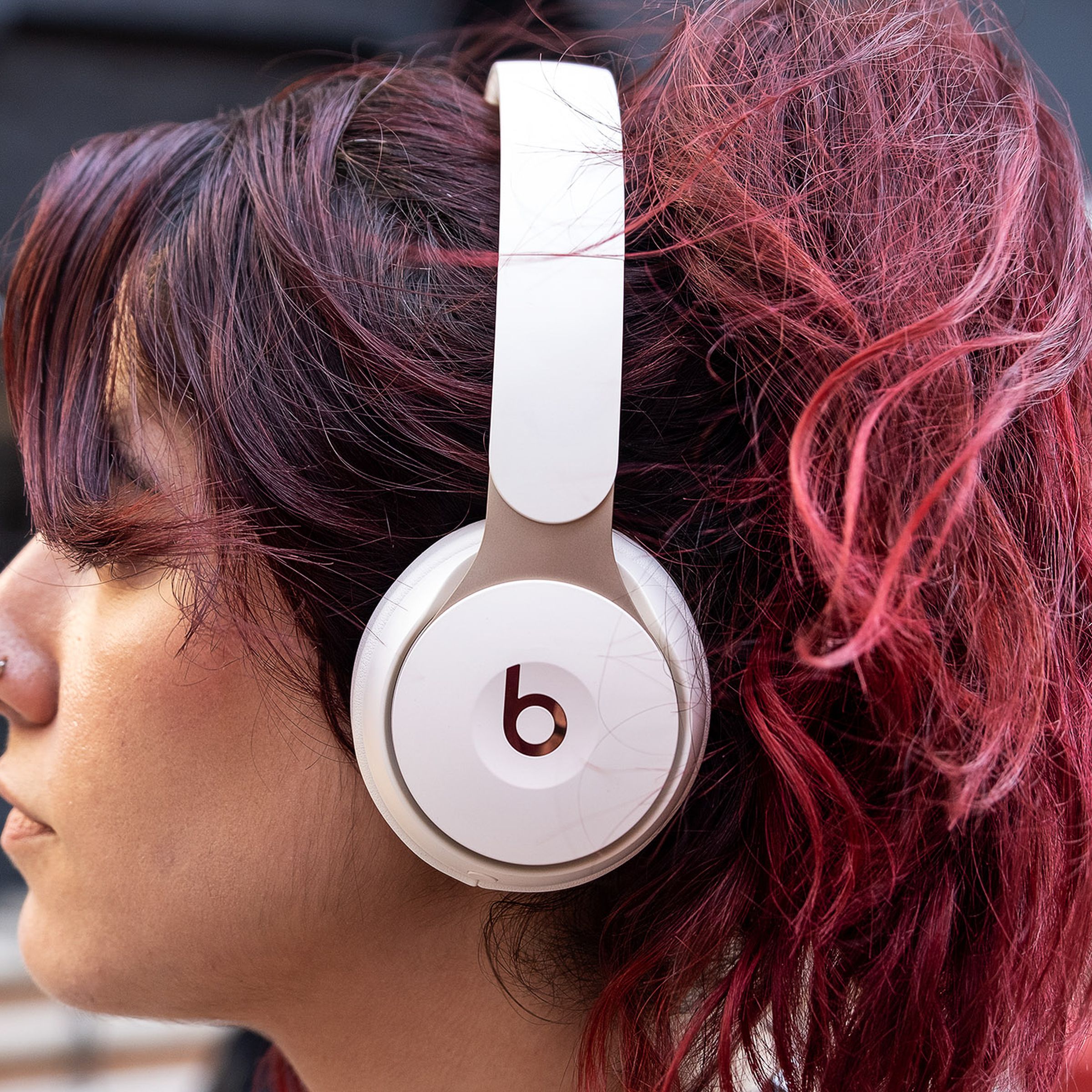 A woman wearing Beats Solo Pro headphones.