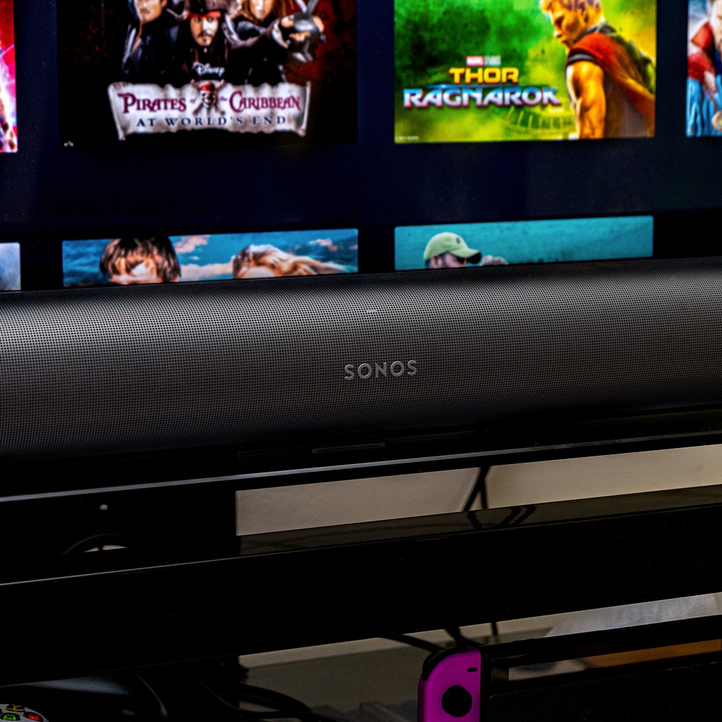 An image of the front of the Sonos Arc soundbar with a TV in the background.