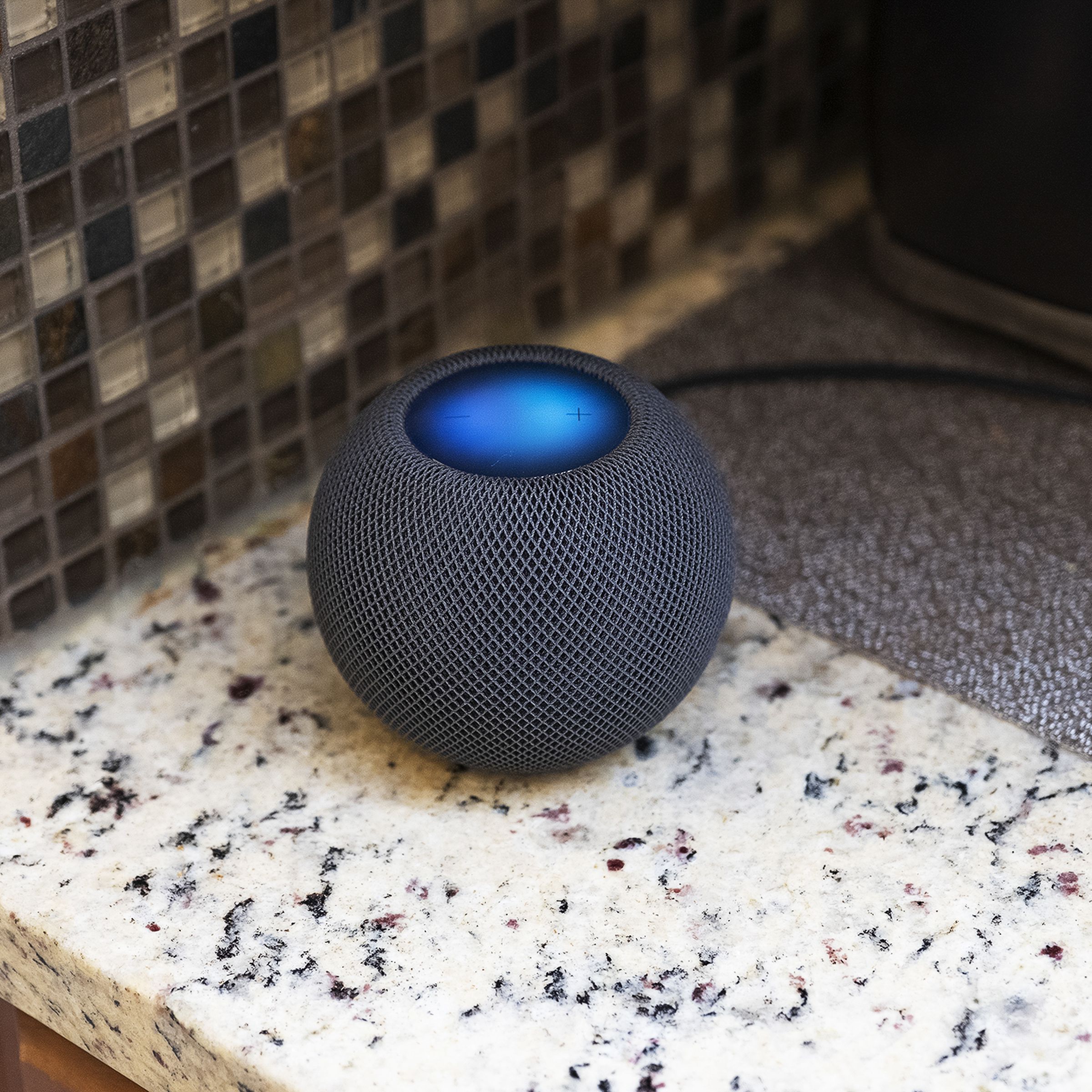 The Apple HomePod Mini sitting on a countertop