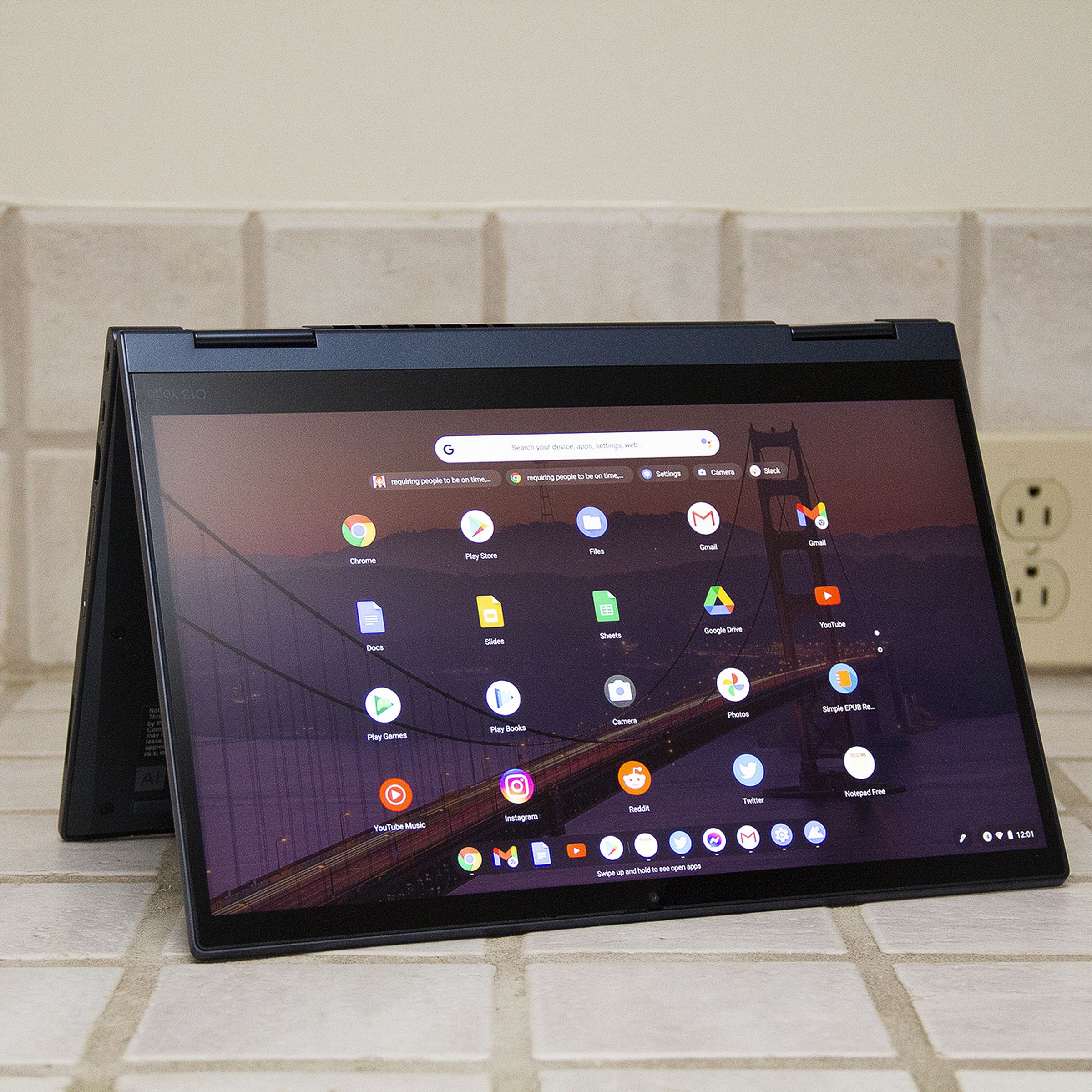 The ThinkPad C13 Yoga Chromebook in tent mode. The screen displays a grid of Android apps.