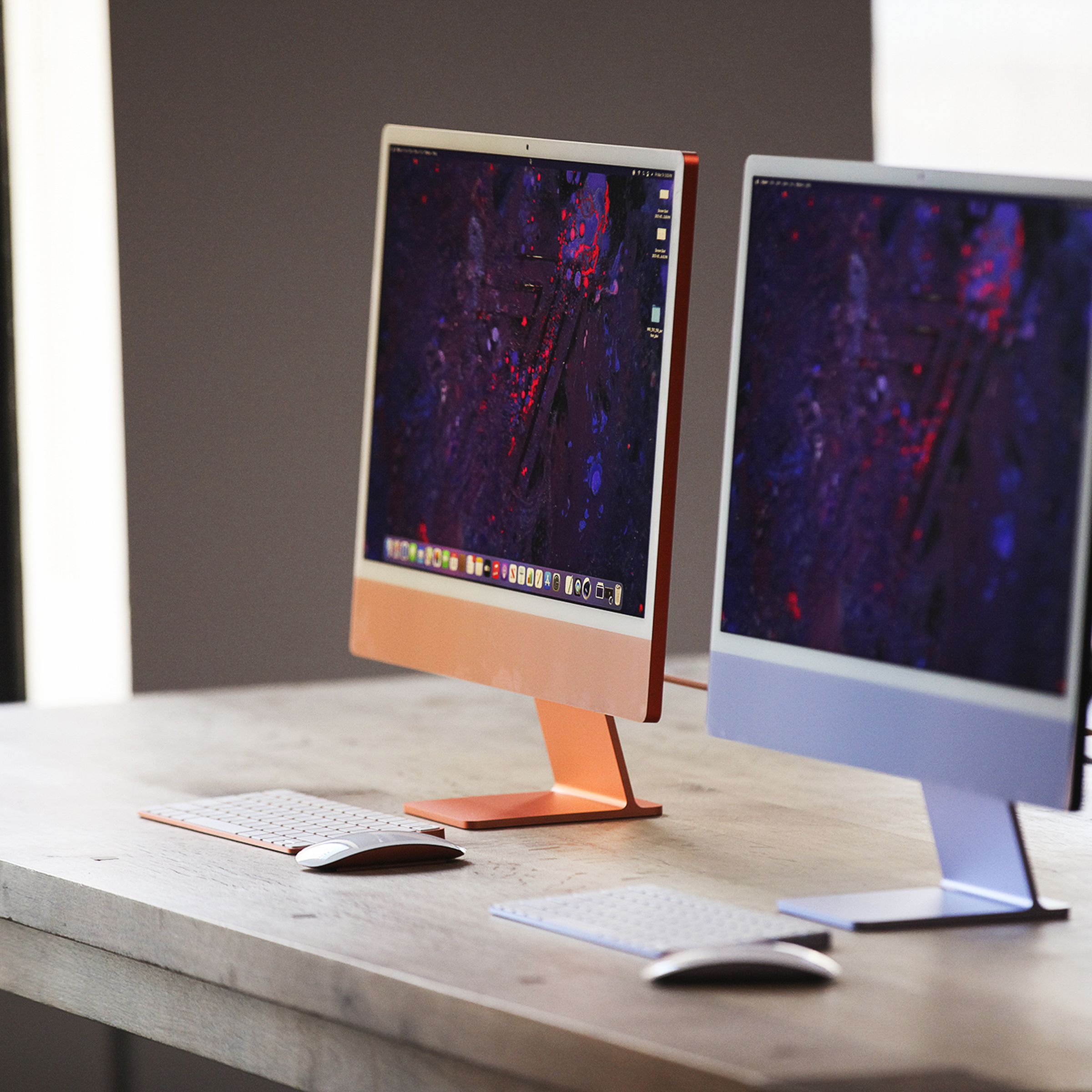 Orange and purple M1 iMacs side by side