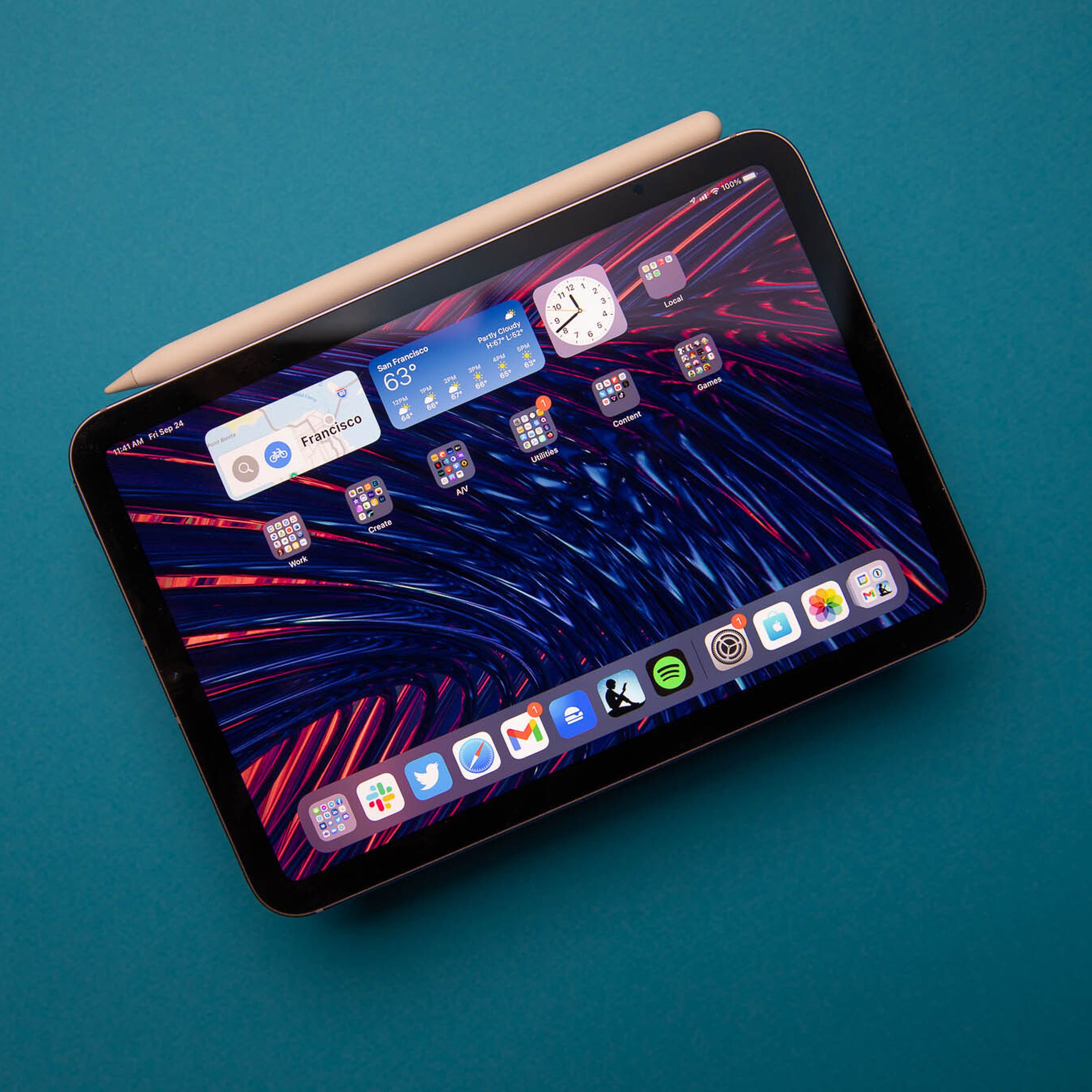 Foto do iPad mini 2021 com o Apple Pencil de segunda geração anexado contra um fundo azul