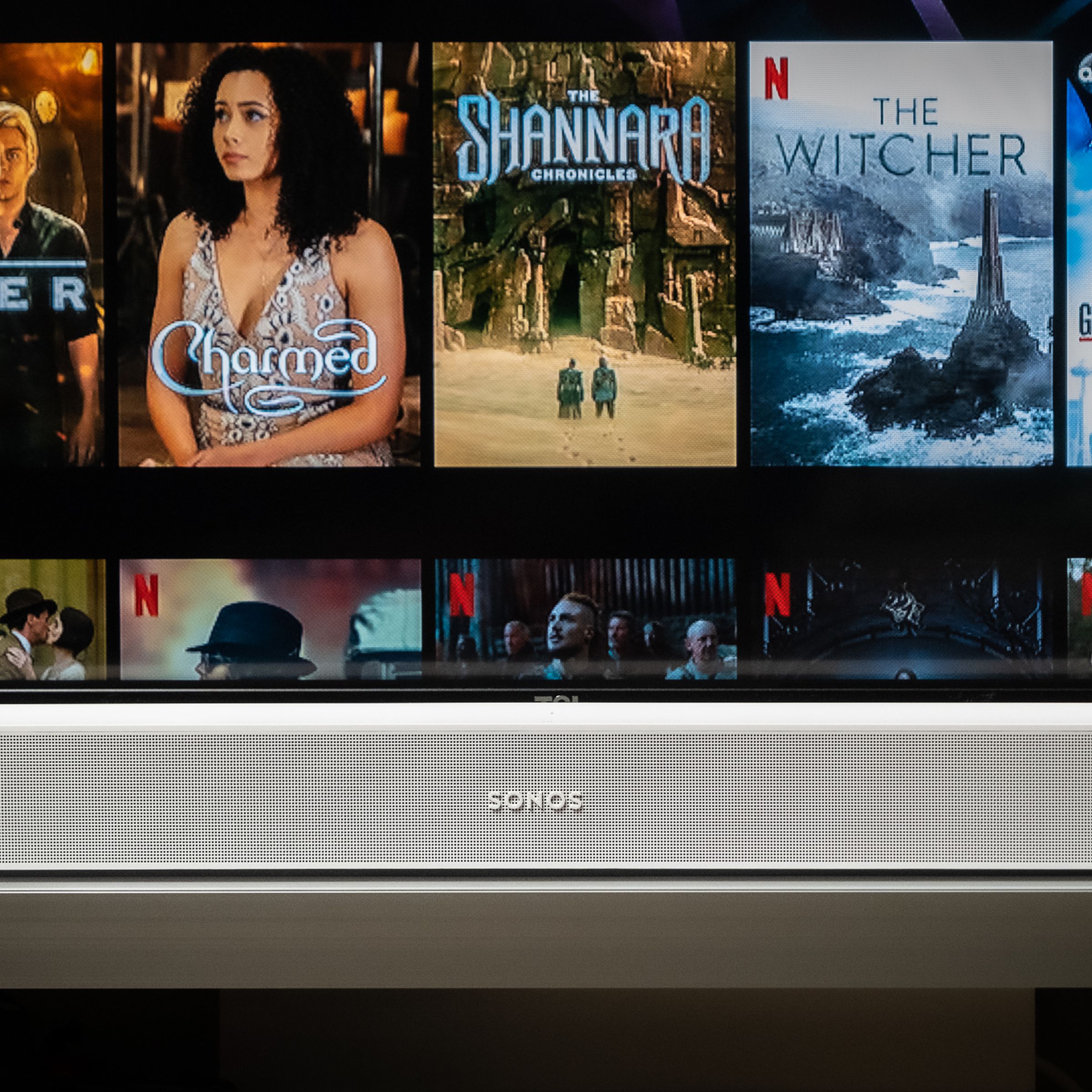 An image of the Sonos Beam soundbar with a TV screen in the background.