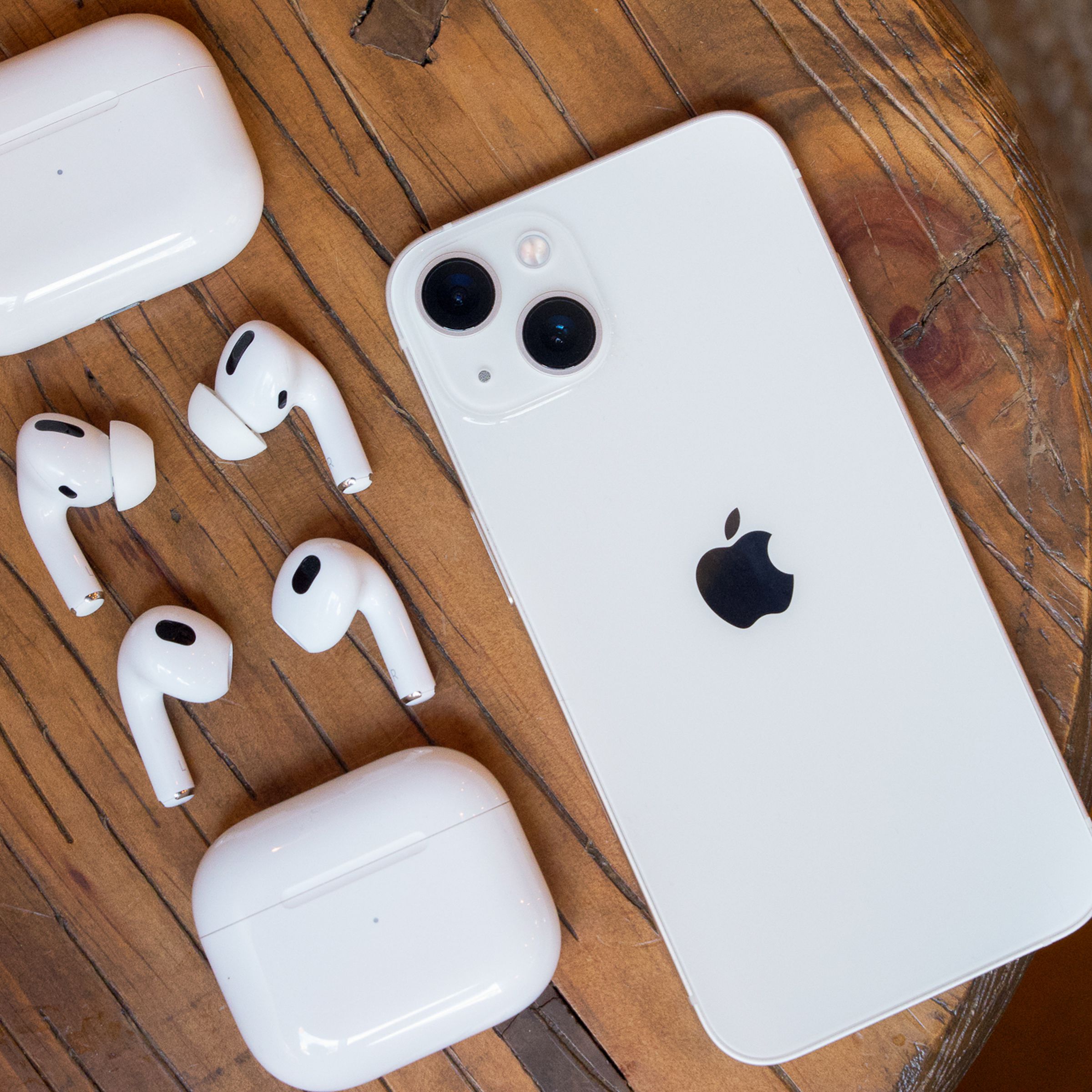 AirPods Pro, AirPods, and an iPhone on a table.