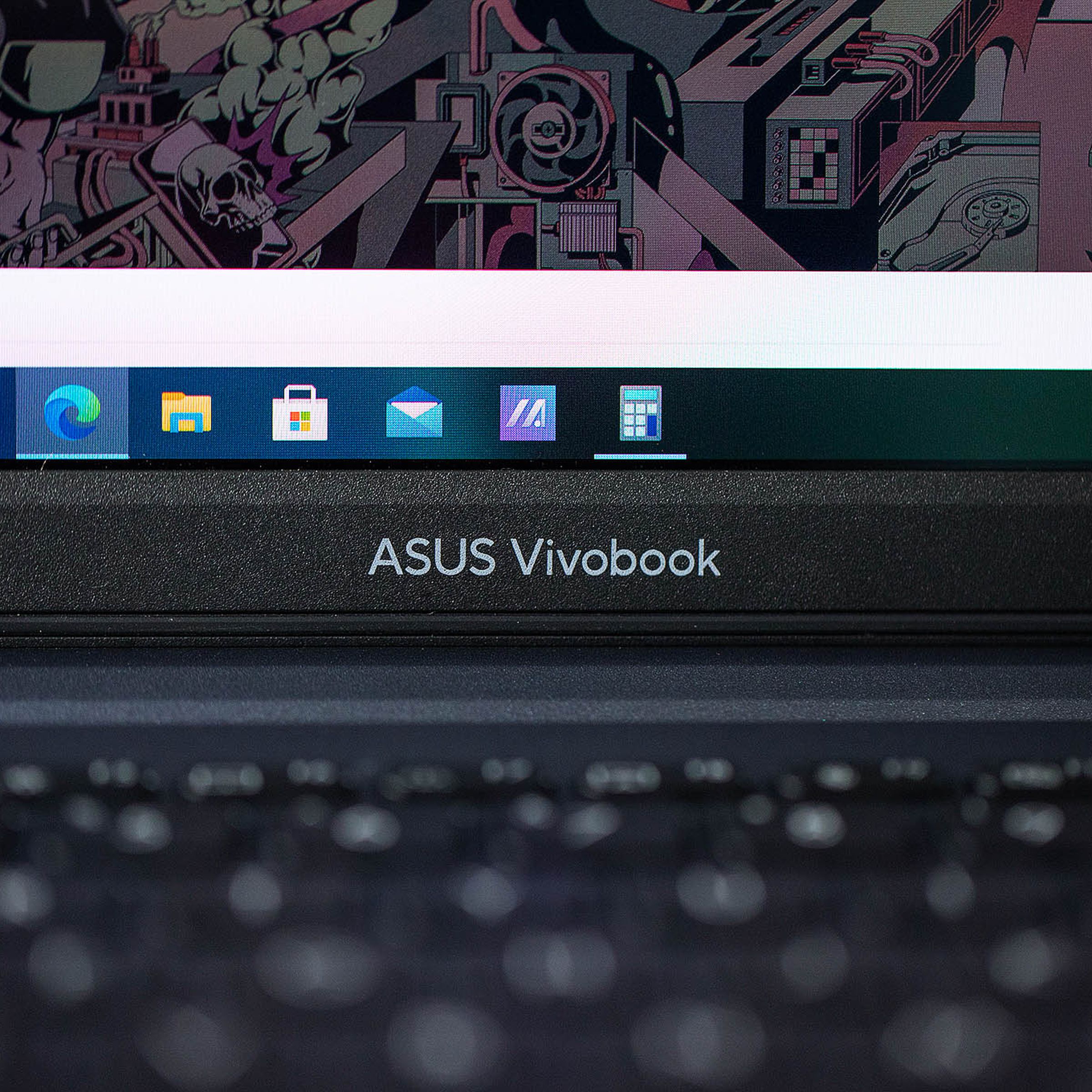 The Asus Vivobook logo on the bottom bezel of the Asus Vivobook Pro 14, up close.