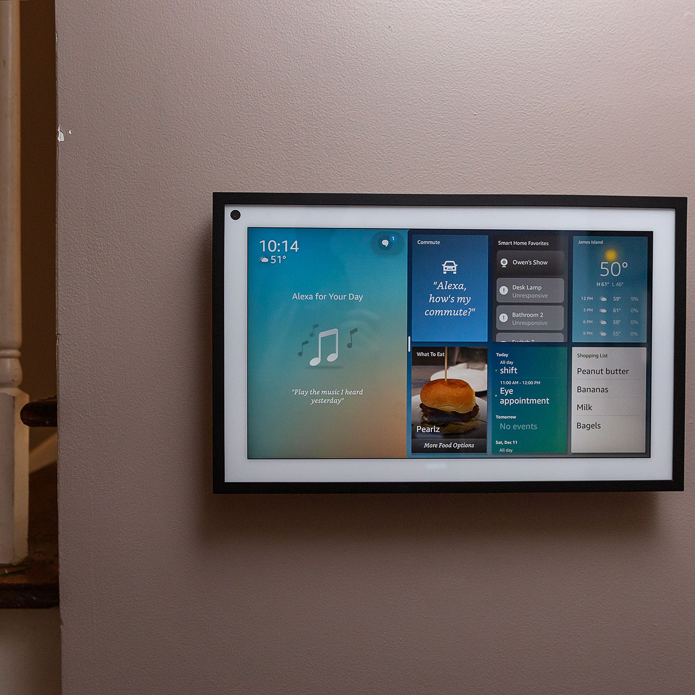 Amazon’s Echo Show 15 mounted on a wall near the staircase. 