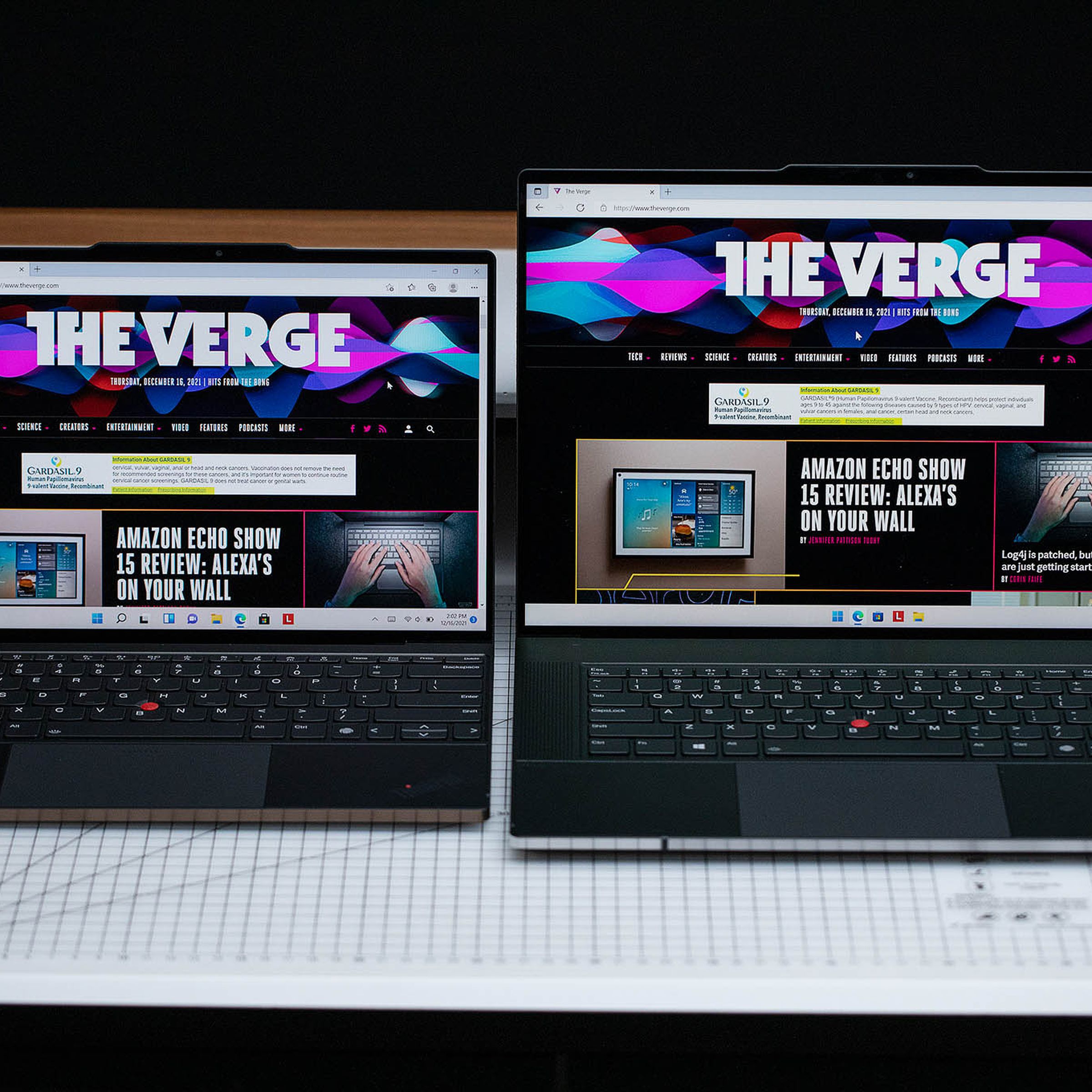 The ThinkPad Z13 and ThinkPad Z16 side-by-side on a gridded table with a black background. Both screens display The Verge homepage.
