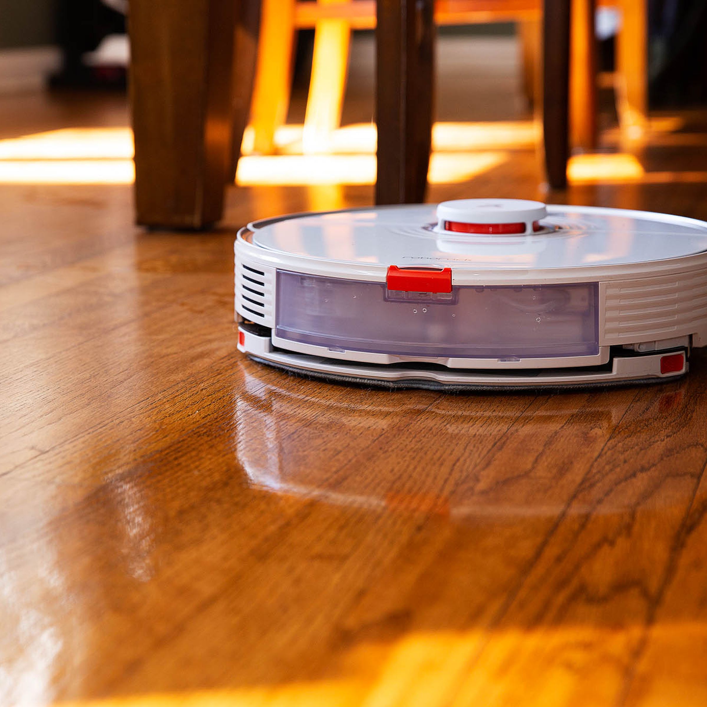 A robot vacuum on a hardwood floor.