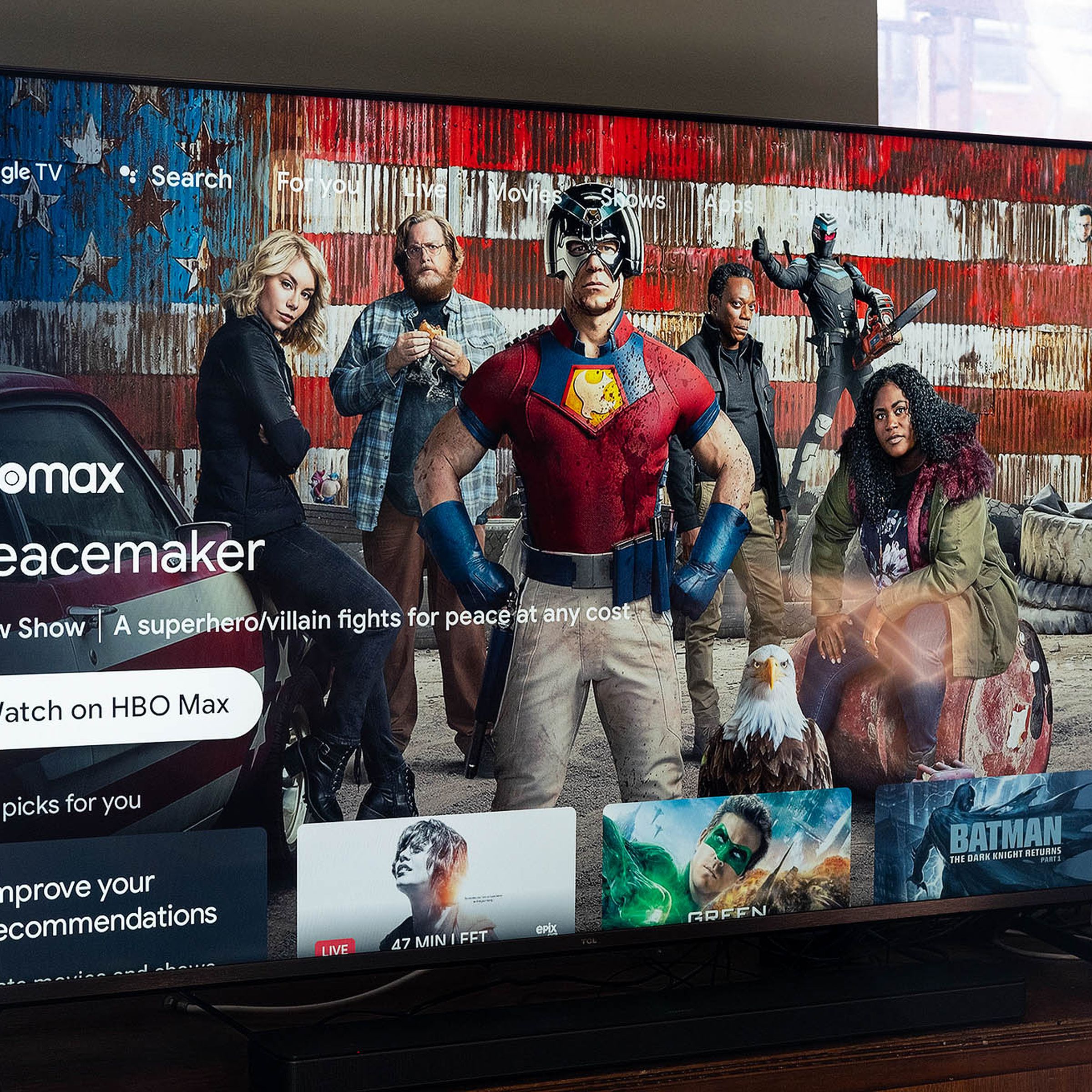 The 55-inch TCL 6-series R646 4K TV is on, displaying the Google TV software homescreen that’s filled with viewing recommendations.