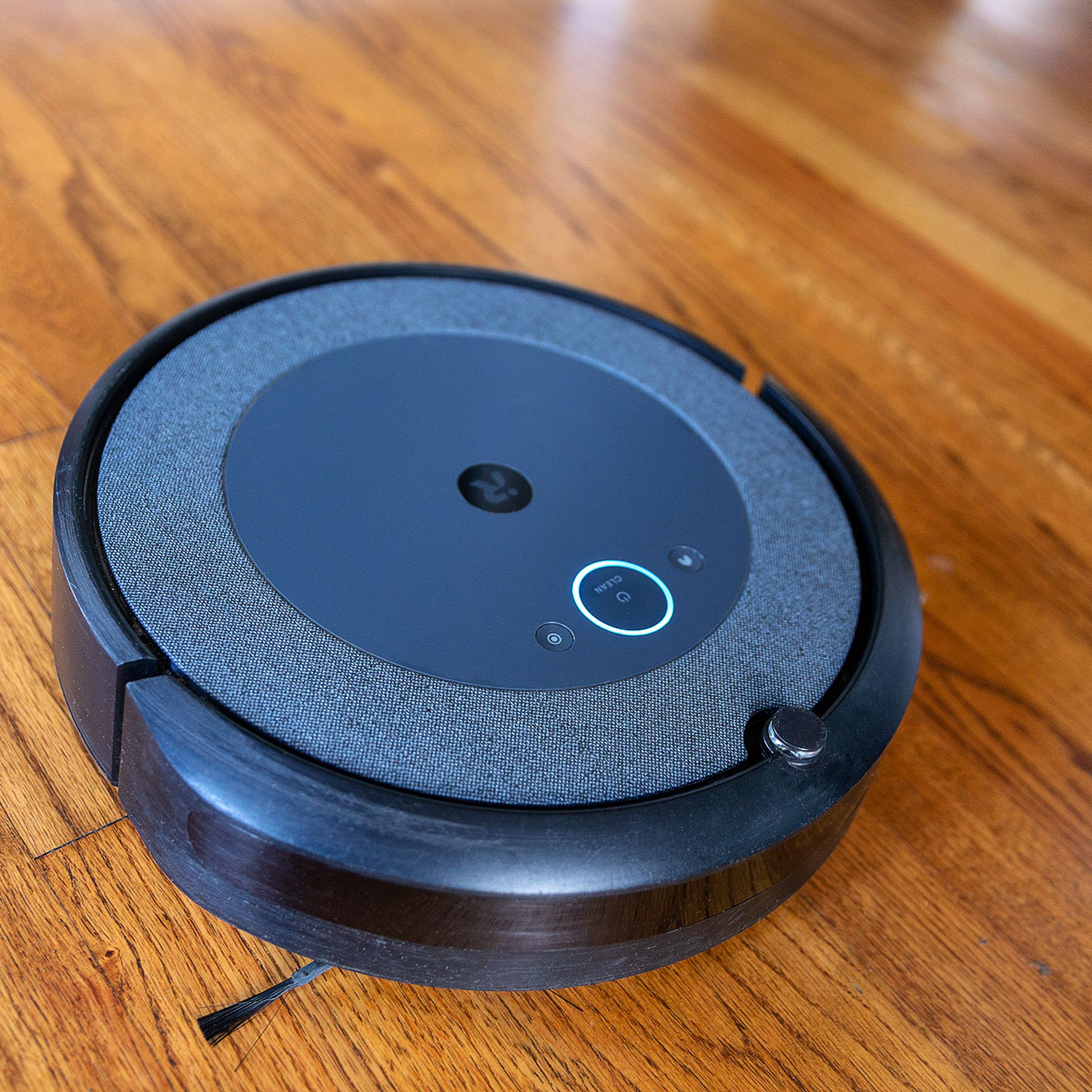 O aspirador robô iRobot Roomba i3 Plus EVO sobre um piso de madeira.