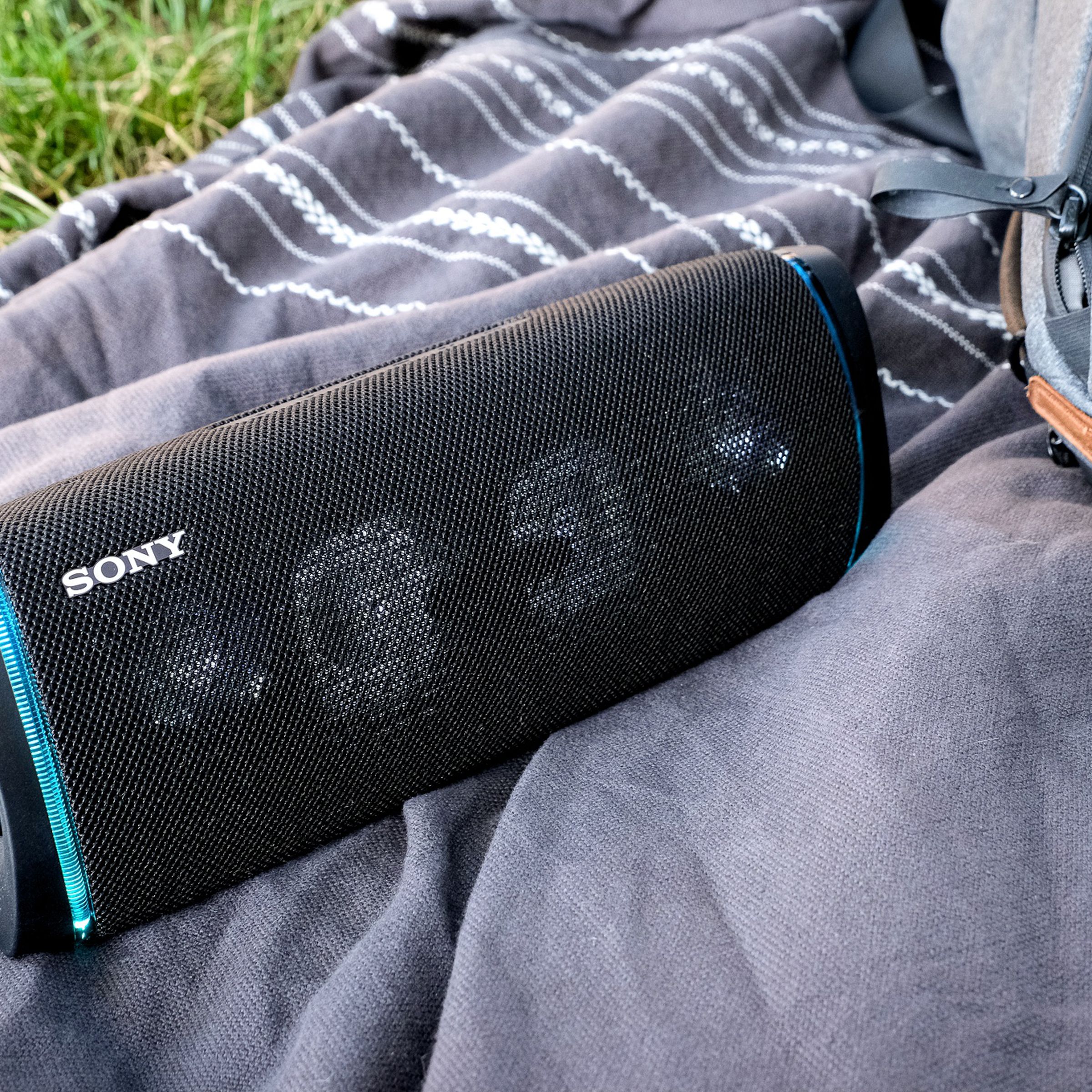 Sony’s SRS-XB43 Bluetooth speaker resting on a blanket outside.