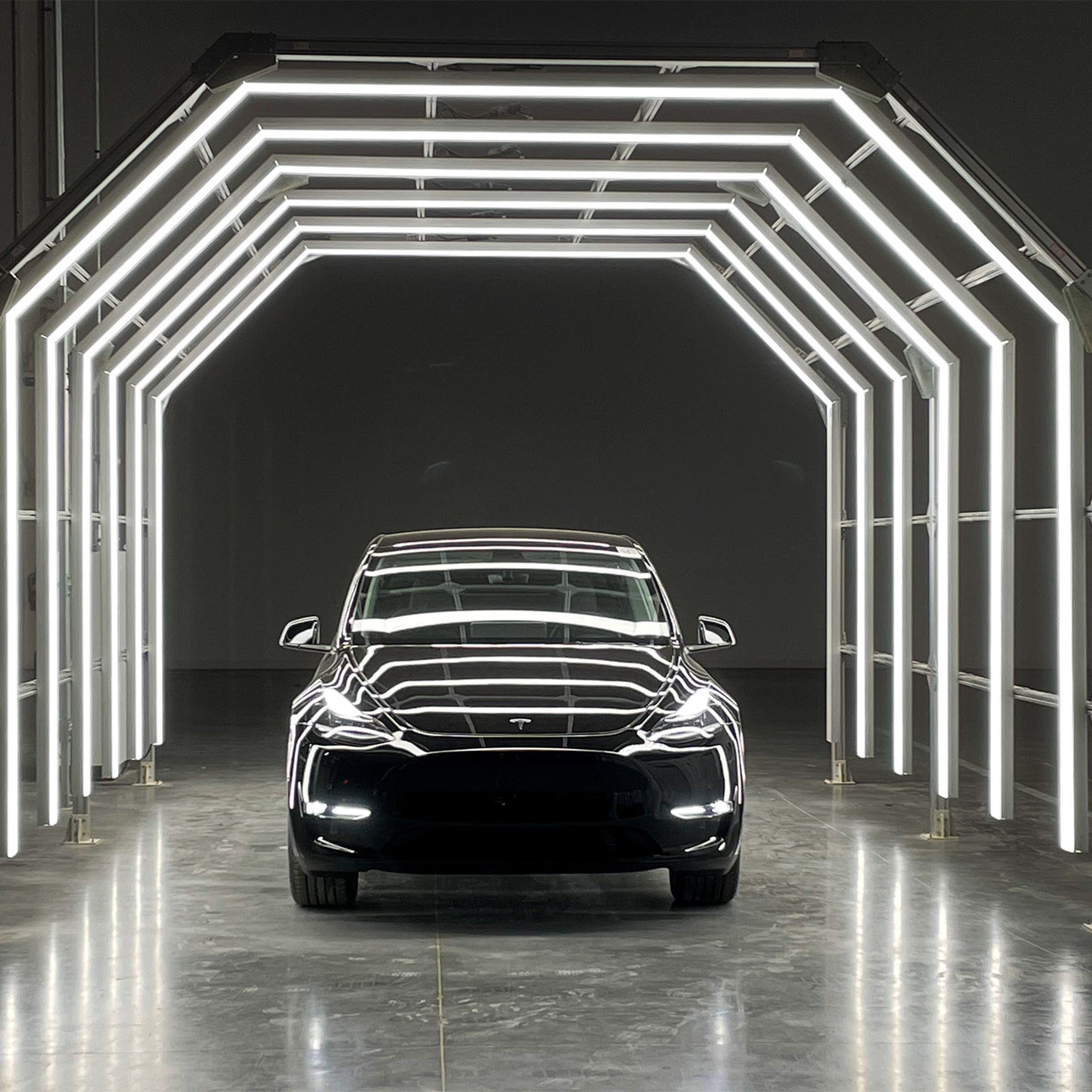 A Tesla vehicle in a lighted tunnel.