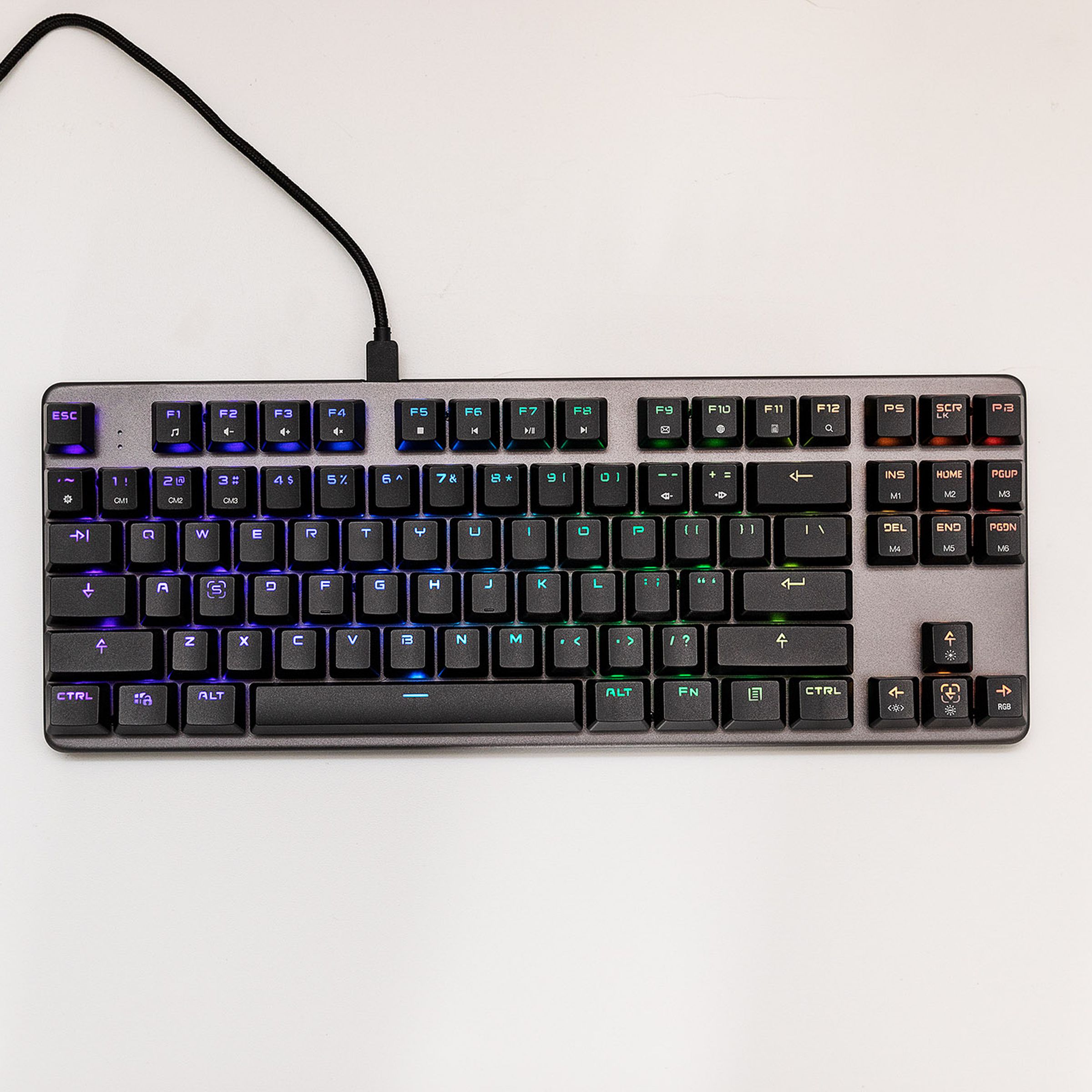 Top-down shot of a tenkeyless mechanical keyboard with RGB shinethrough backlighting.