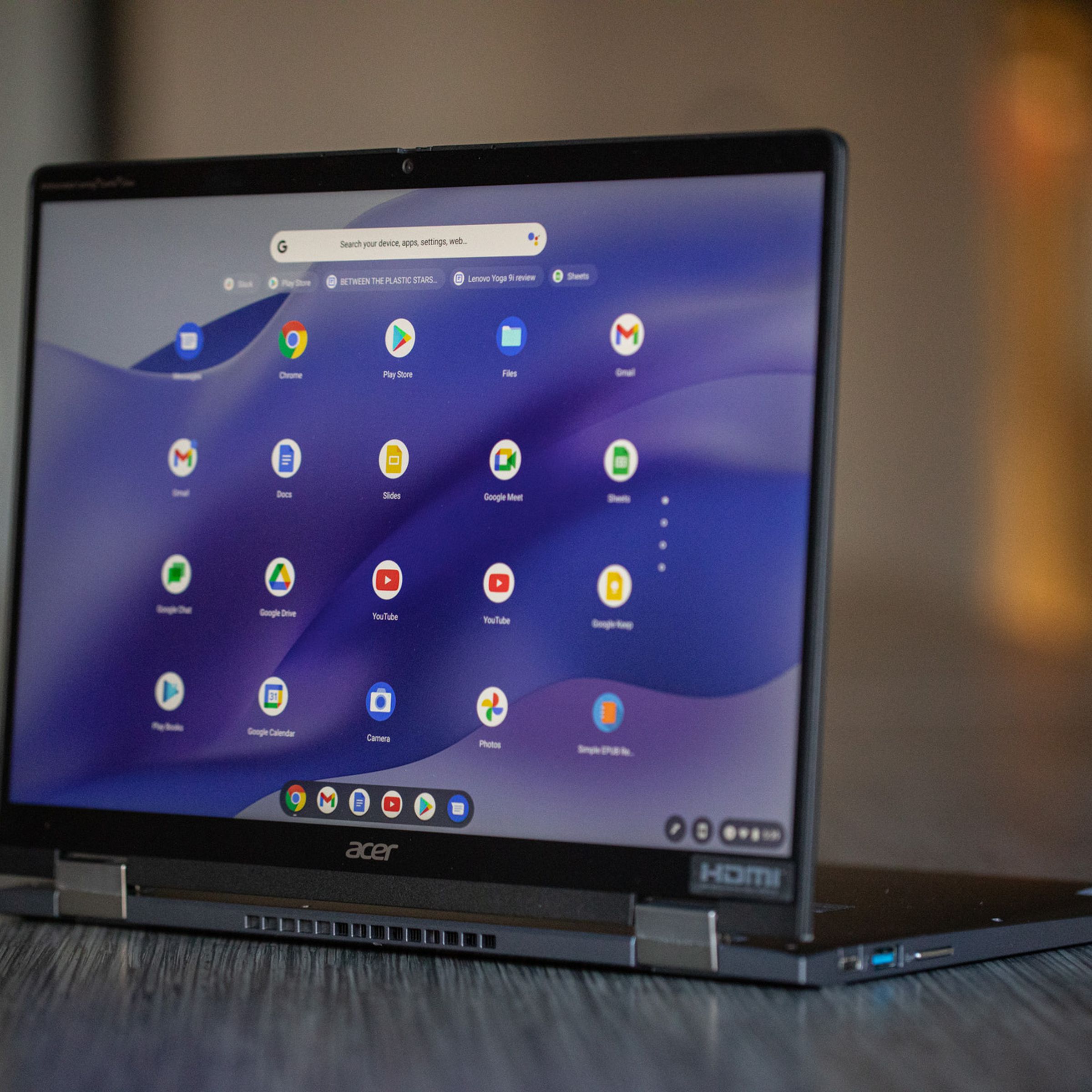 The Acer Chromebook Spin 714 open on a conference room table. The screen displays the ChromeOS Launcher.