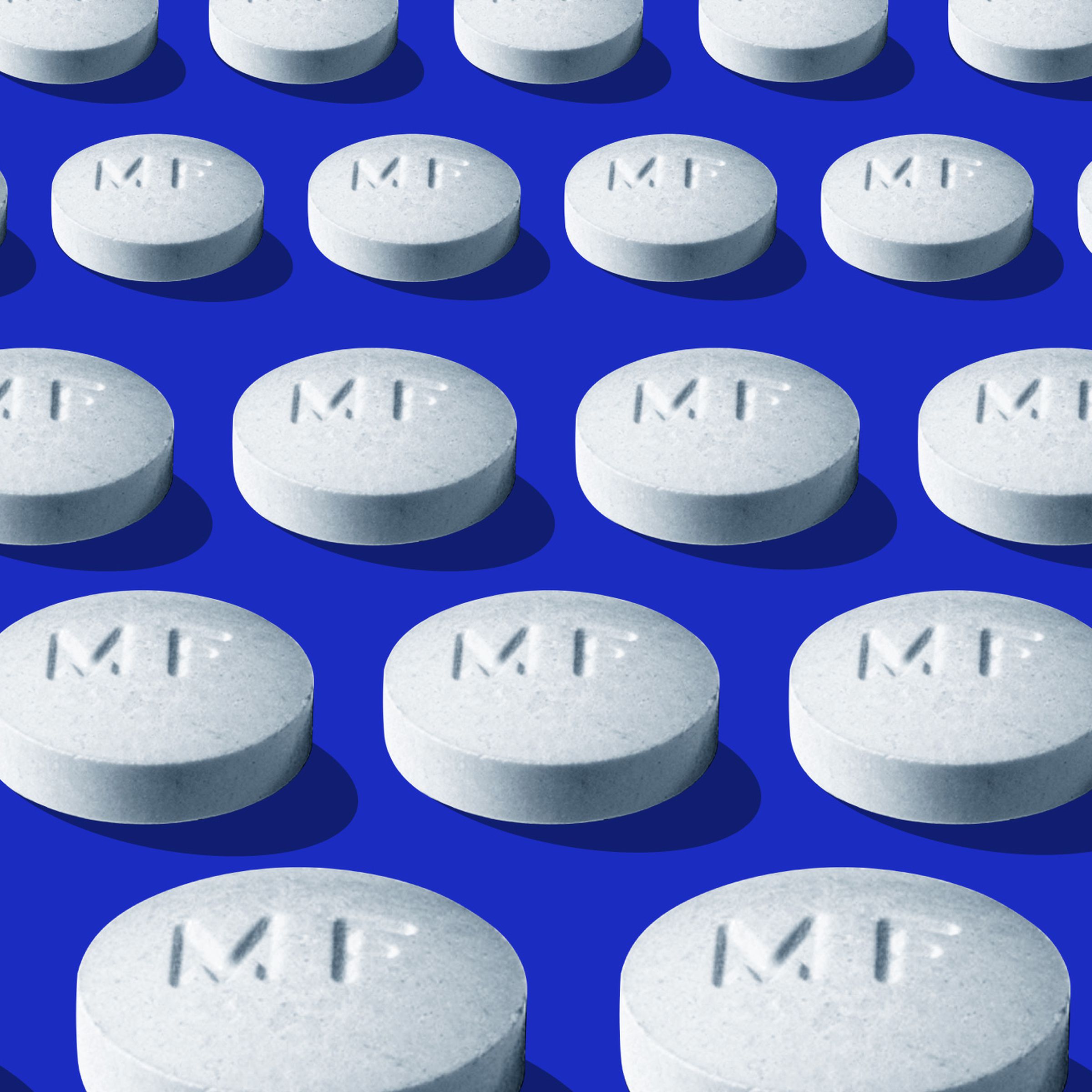 Several rows of white pills on a blue background.