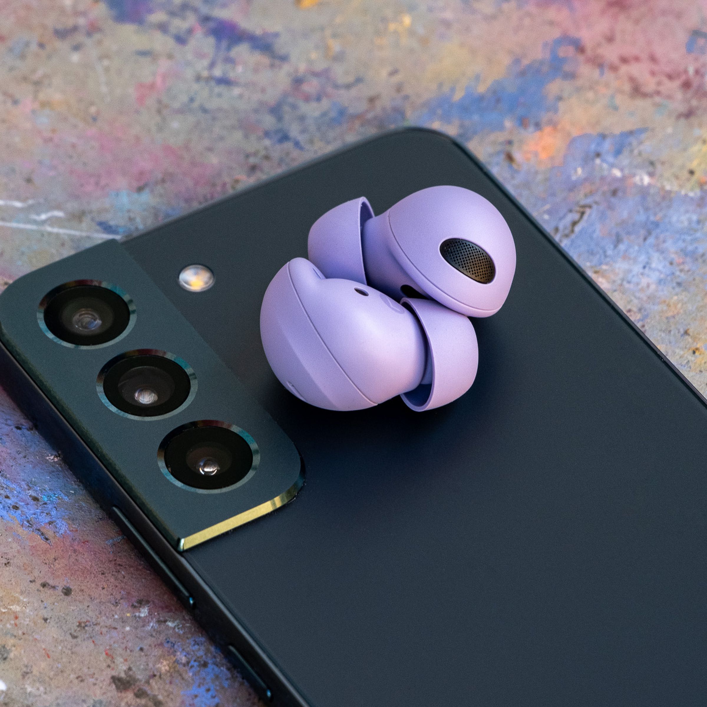 A pair of Samsung’s new Galaxy Buds 2 Pro sitting on top of a phone.