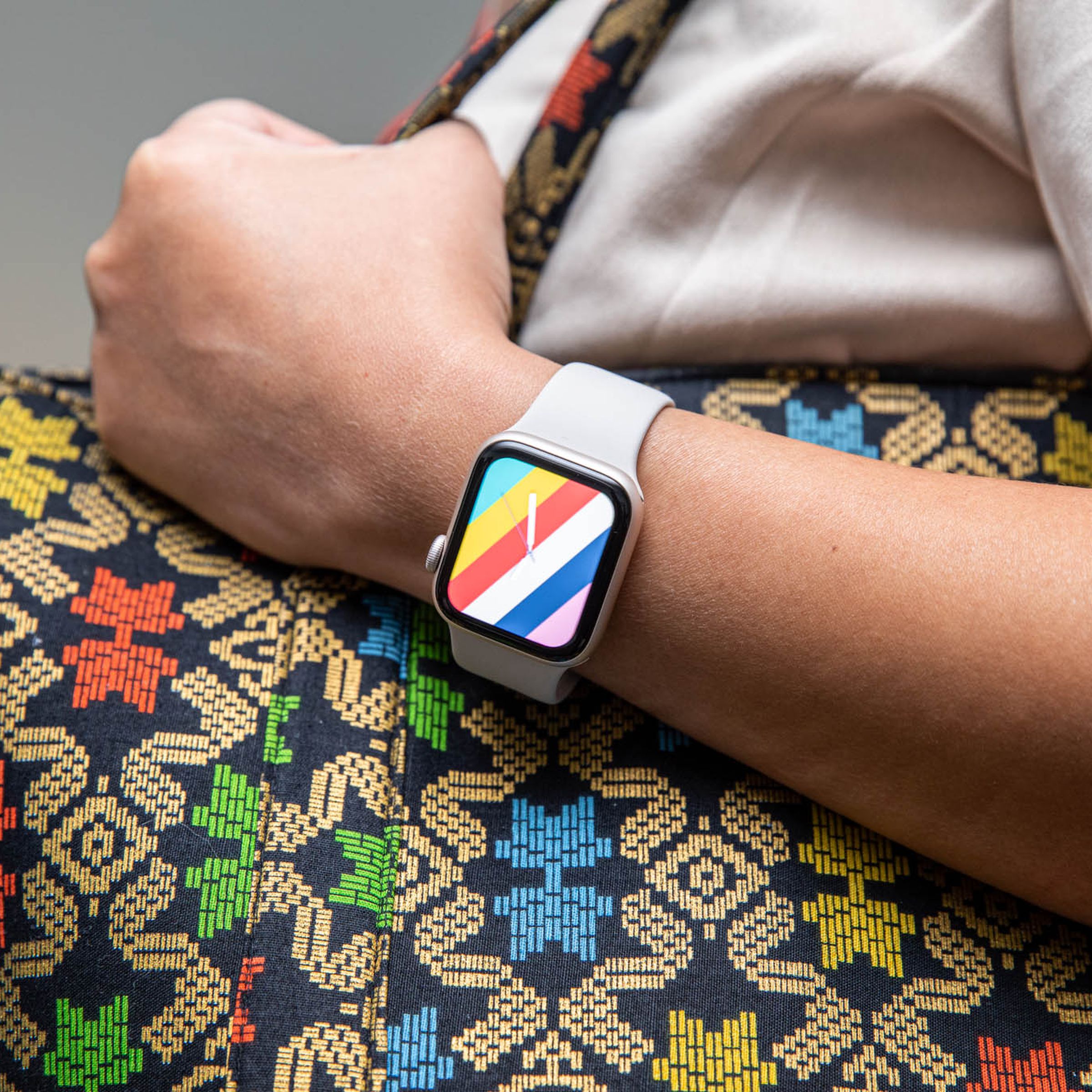 Người phụ nữ cầm ví trong khi làm mẫu mặt đồng hồ Stripes trên Apple Watch SE (2022)
