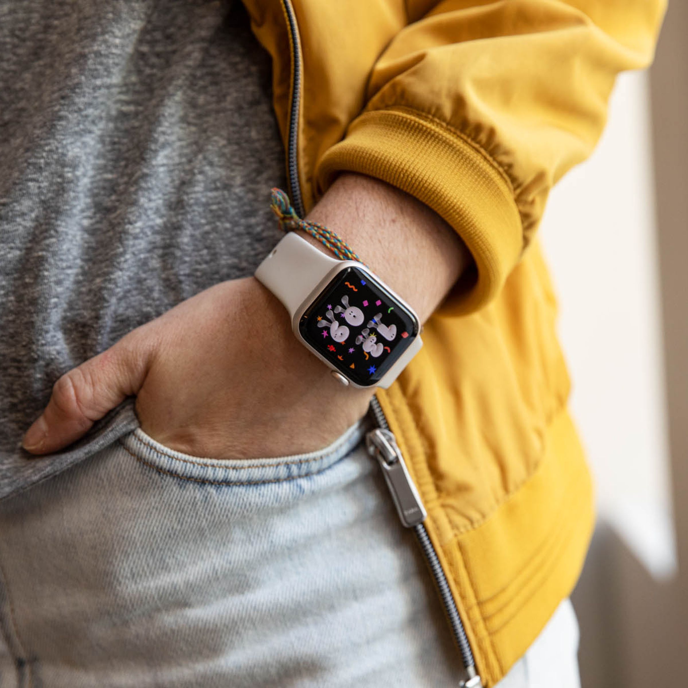 رجل يرتدي سترة صفراء طرازات Apple Watch SE (2022)