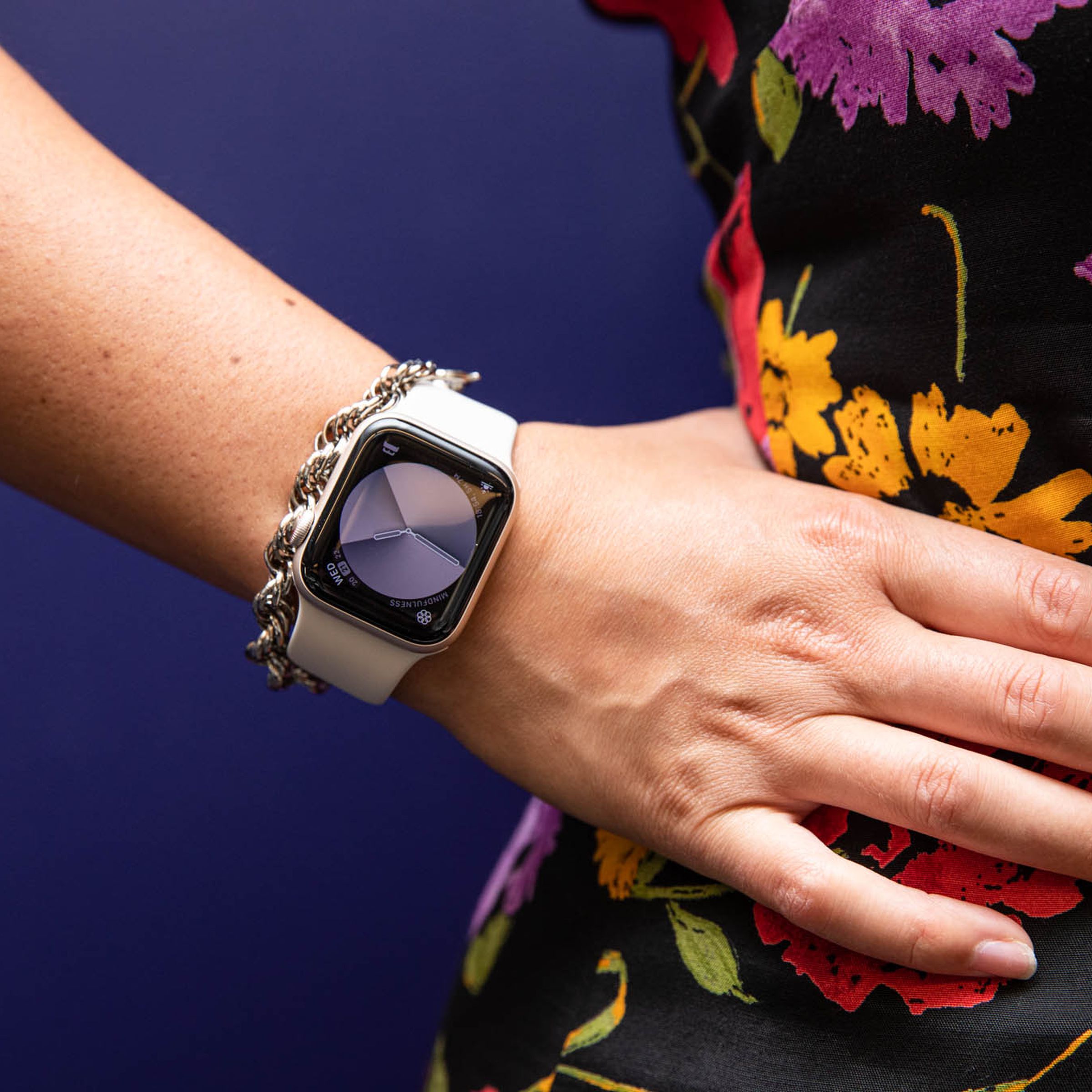 Woman in floral dress with hand on hip modeling Apple watch SE (2022)