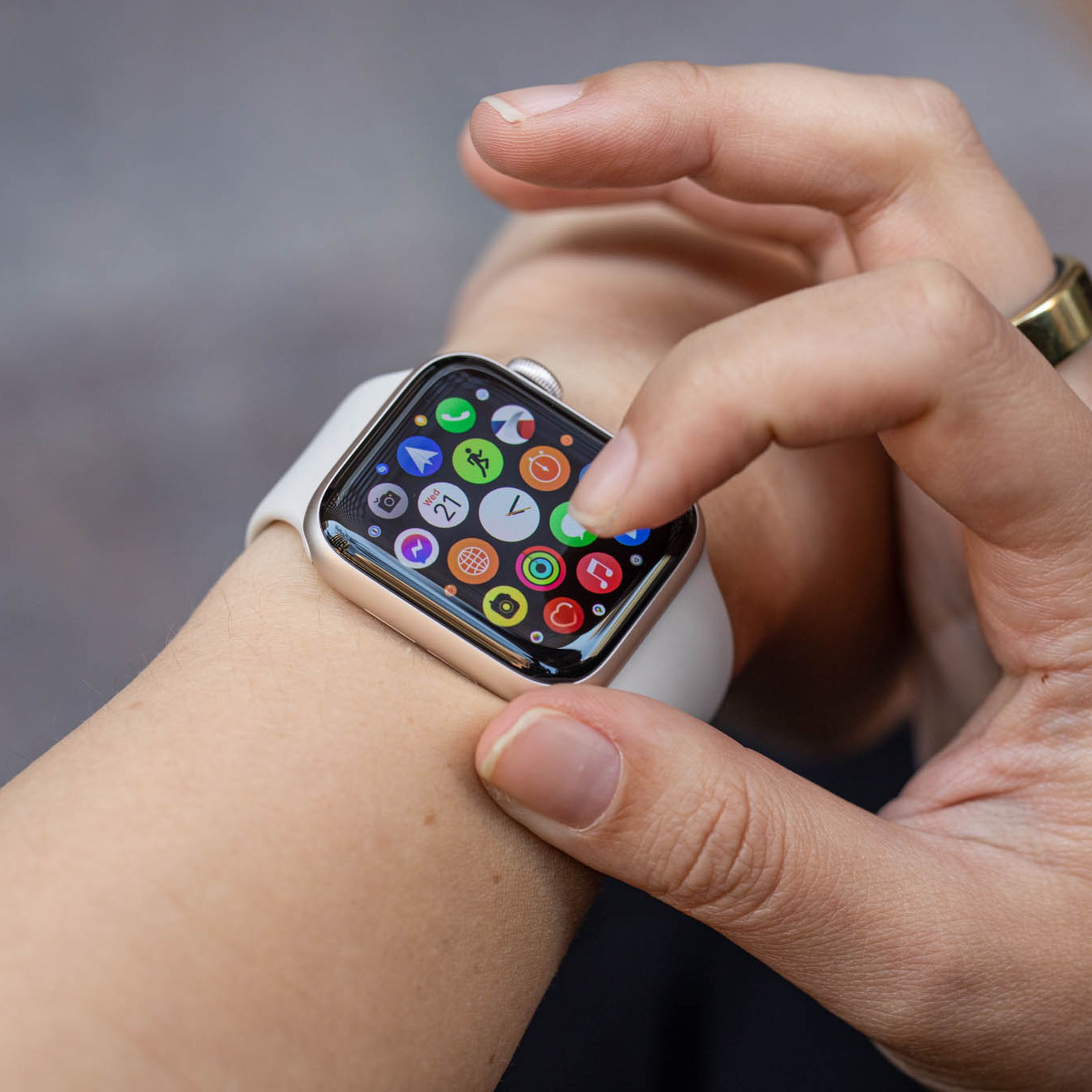 Woman looks at the app grid of the Apple Watch SE (2022).