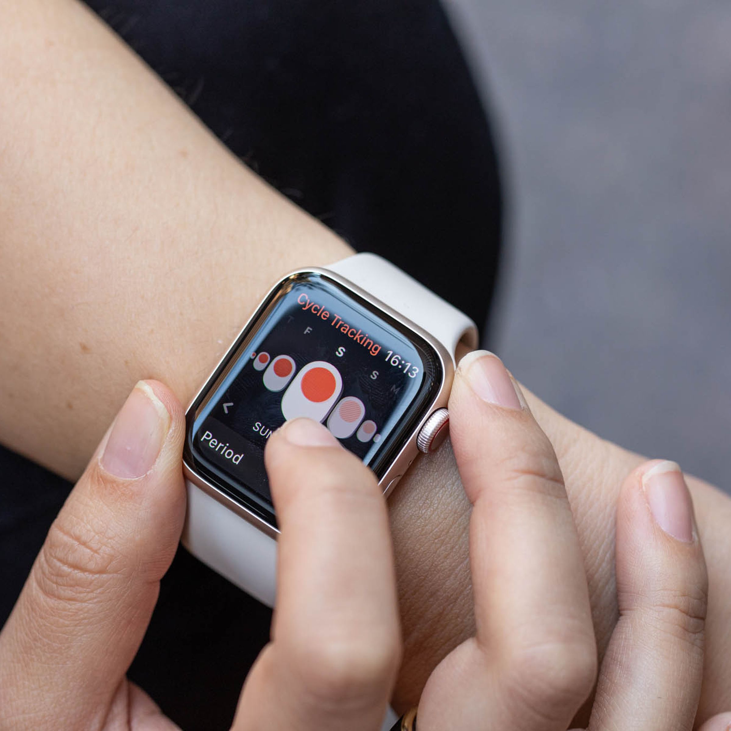 Apple Watch on a wrist showing a screen that lets a user log a period