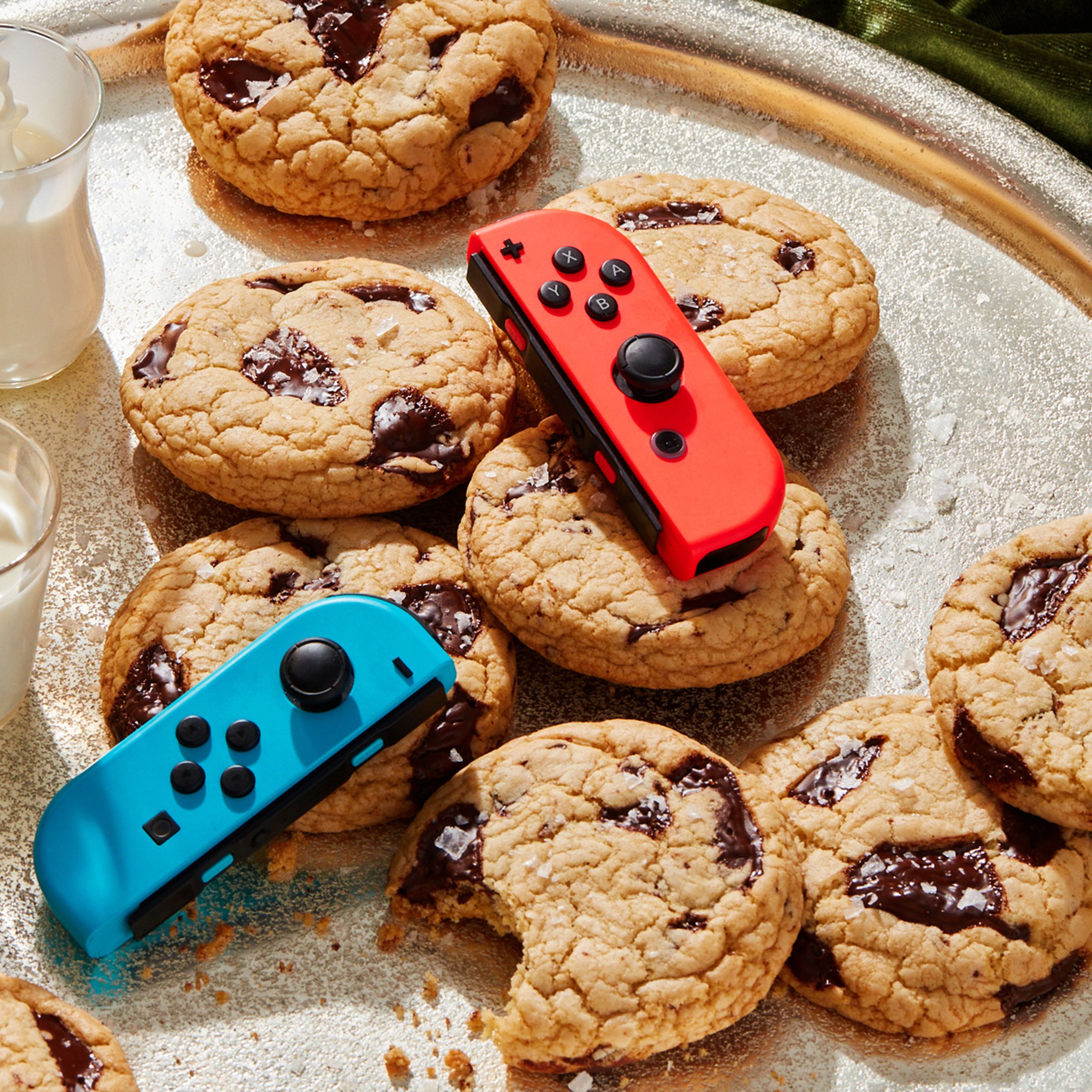 Nintendo Switch Joy-Con controllers on a tray of milk and cookies