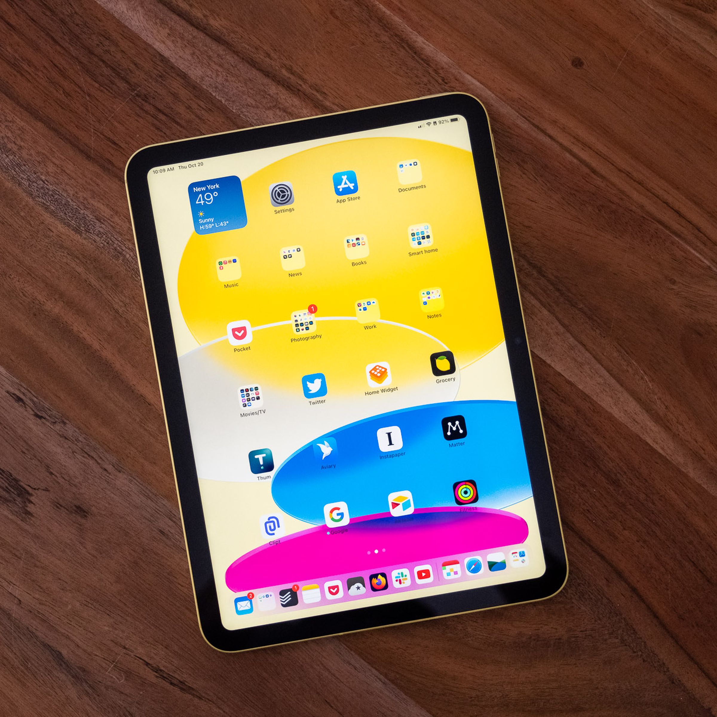 The 10th-gen iPad in yellow, resting face up on a wooden table.