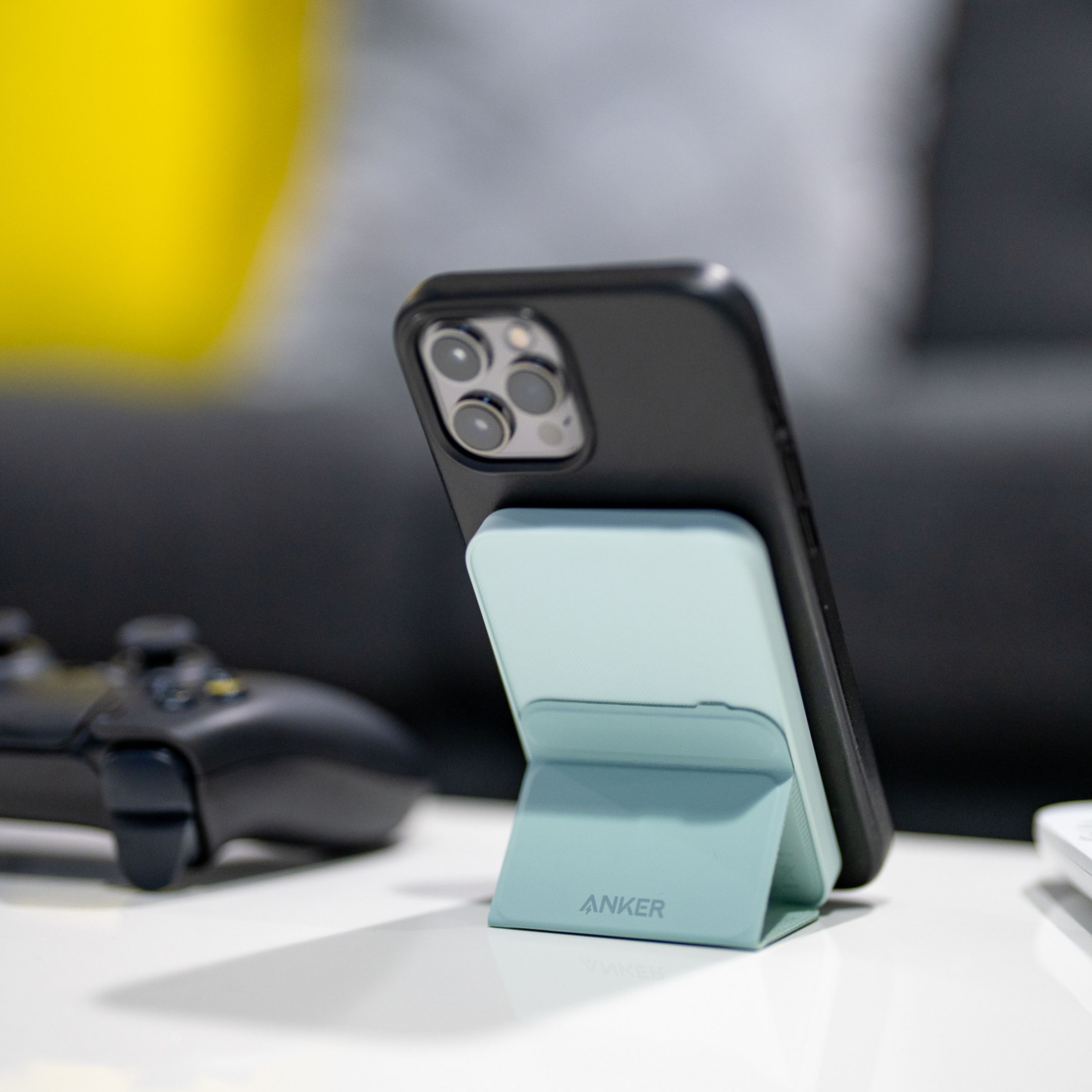 Anker’s 621 Magnetic Battery (MagGo) holding up an iPhone with its kickstand on a desk.