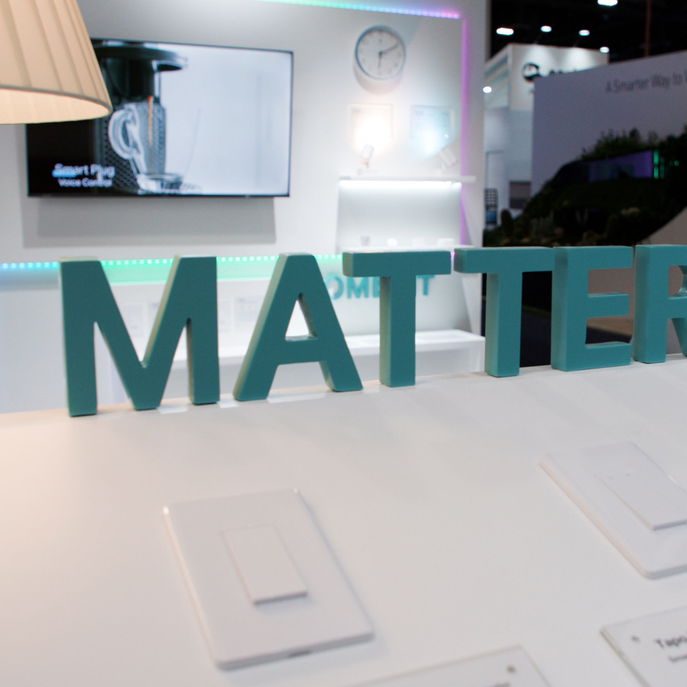 A green Matter sign above smart switches in a booth on the trade show floor.
