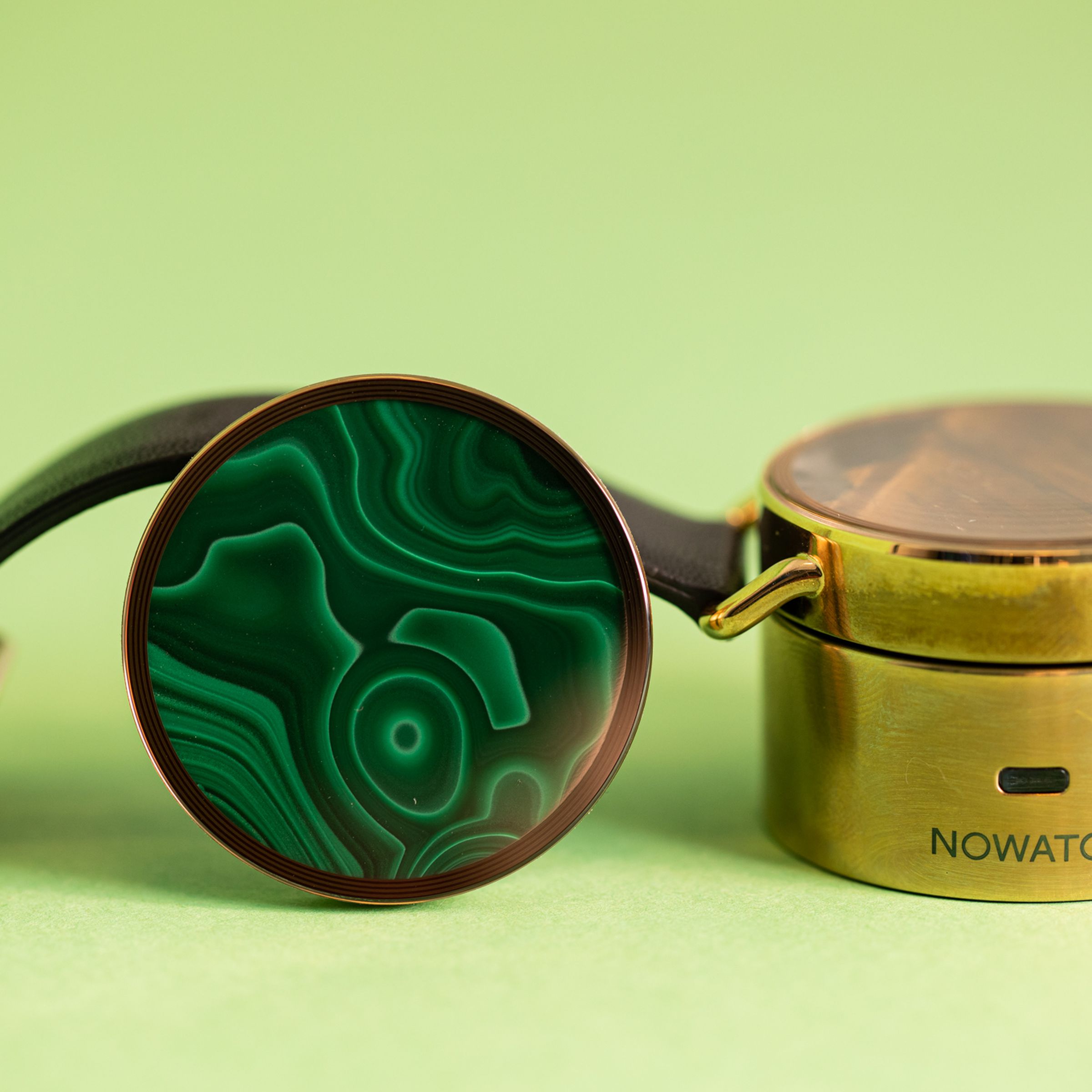 Nowatch device on its charger while an alternate agate disc is propped up next to it.