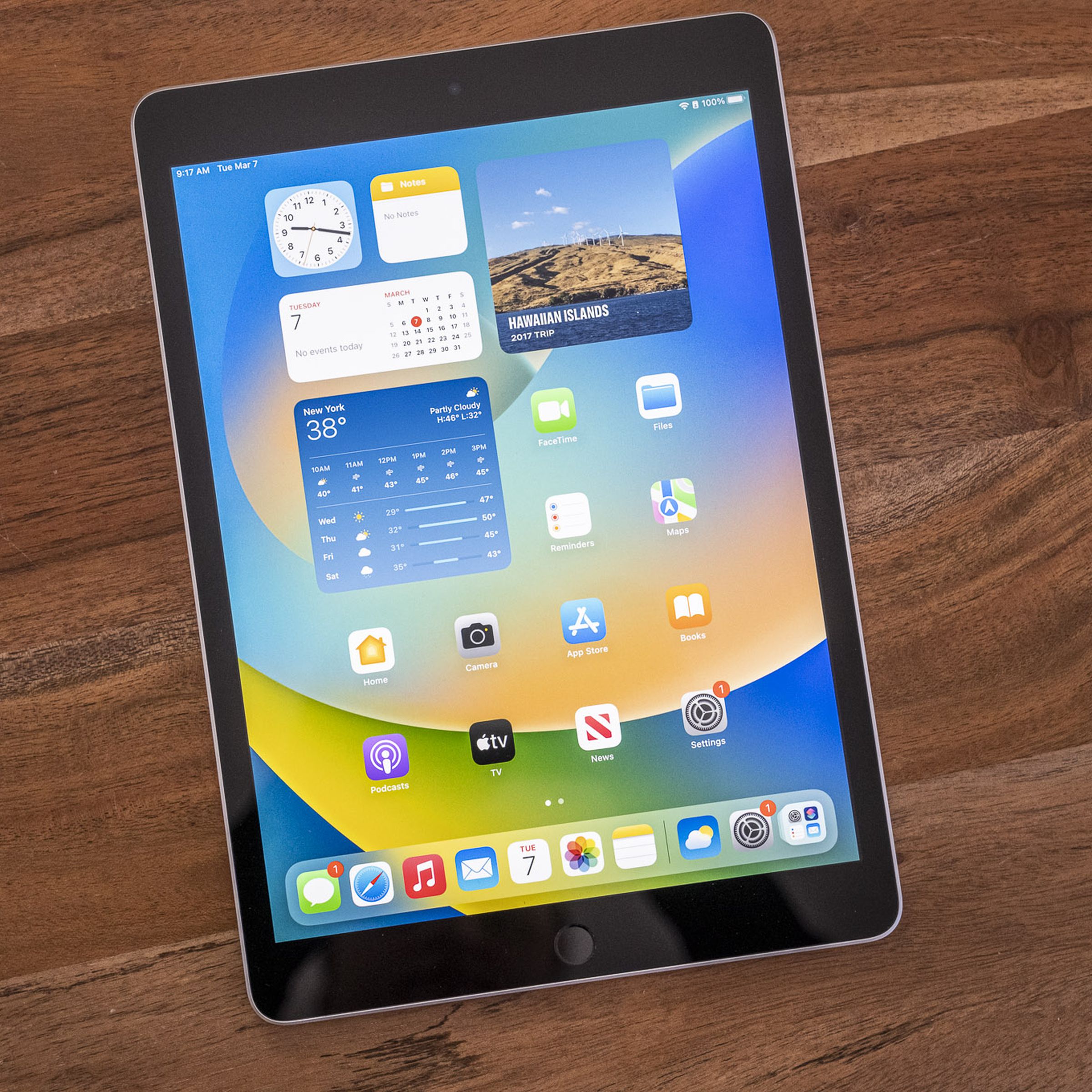 Apple’s ninth-gen iPad on a wooden table, viewed from the top down