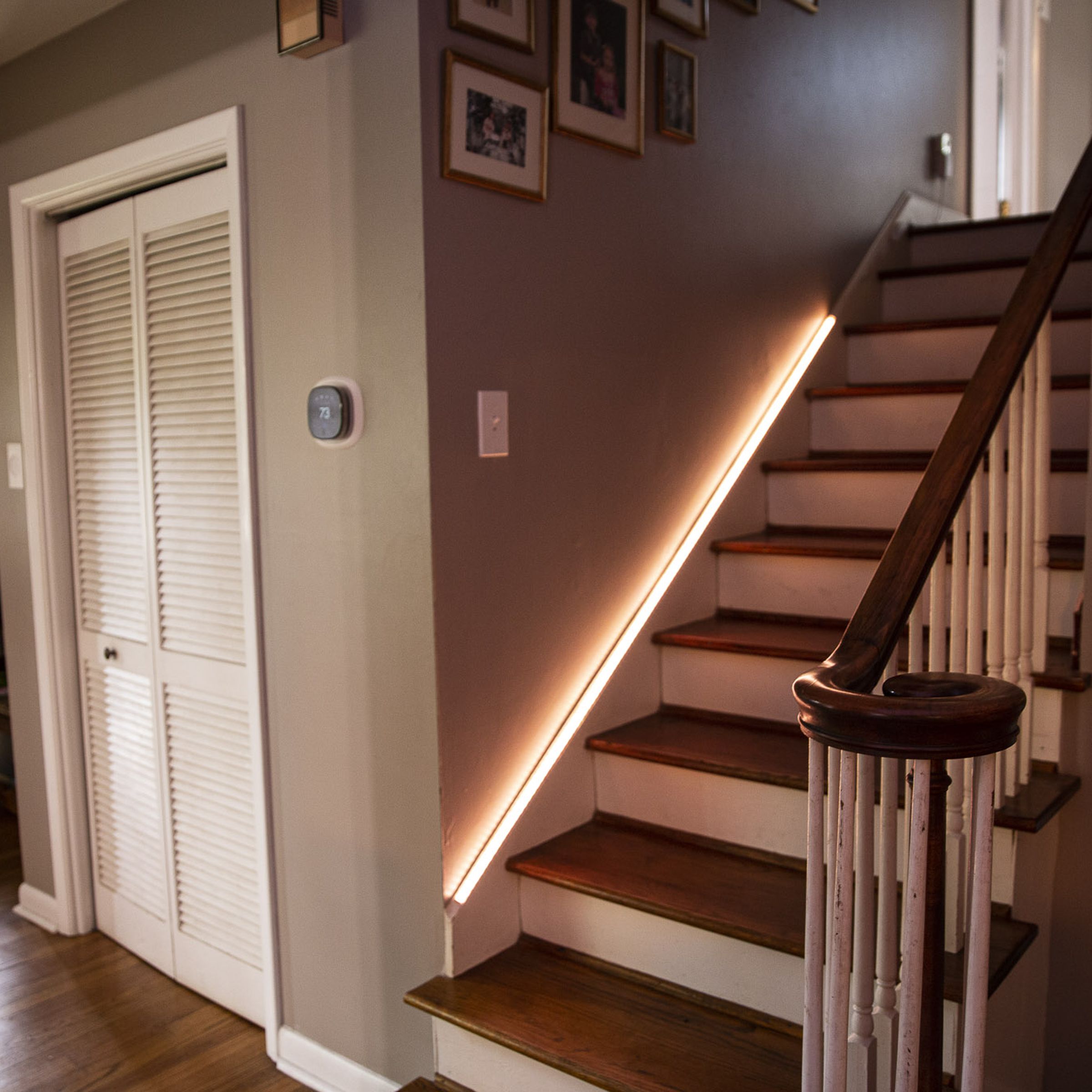 Govee’s LED Strip Light M1 Matter hanging on a staircase railing while raiding white light.