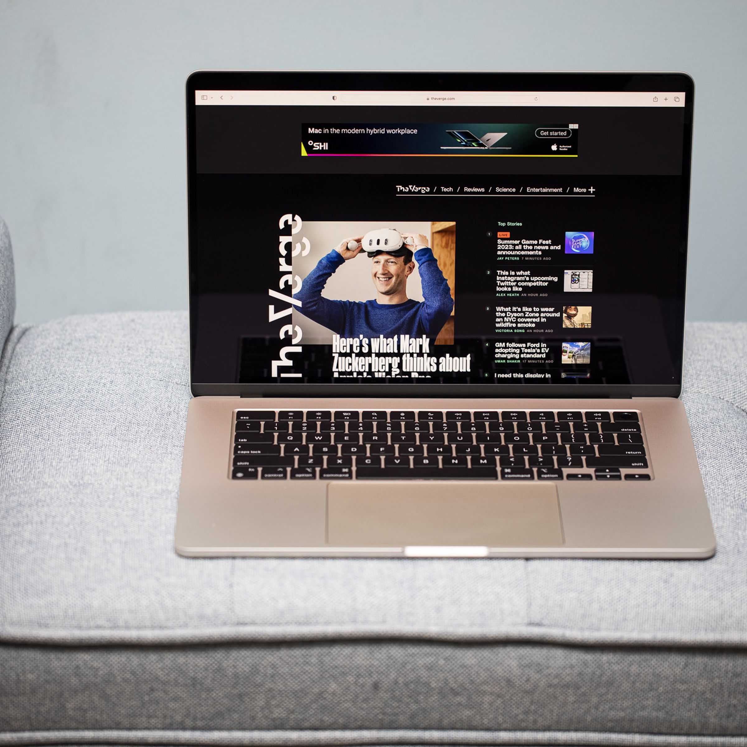 A 15-inch MacBook Air open on a gray couch.