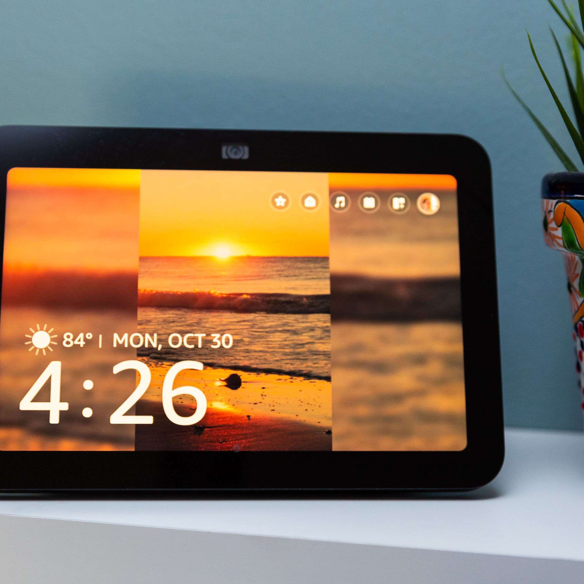 The third-generation Echo Show facing the camera with its display on and four widgets up in the top right corner.