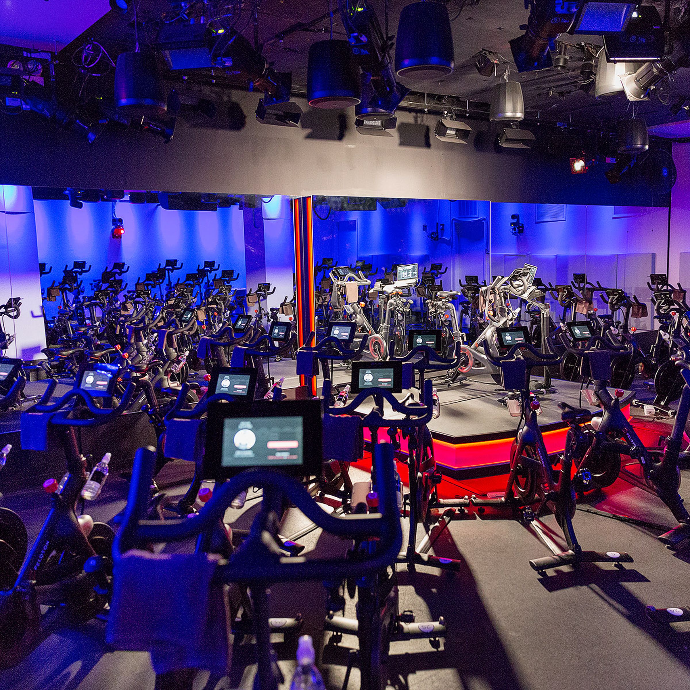 An empty Peloton studio with several of its bikes