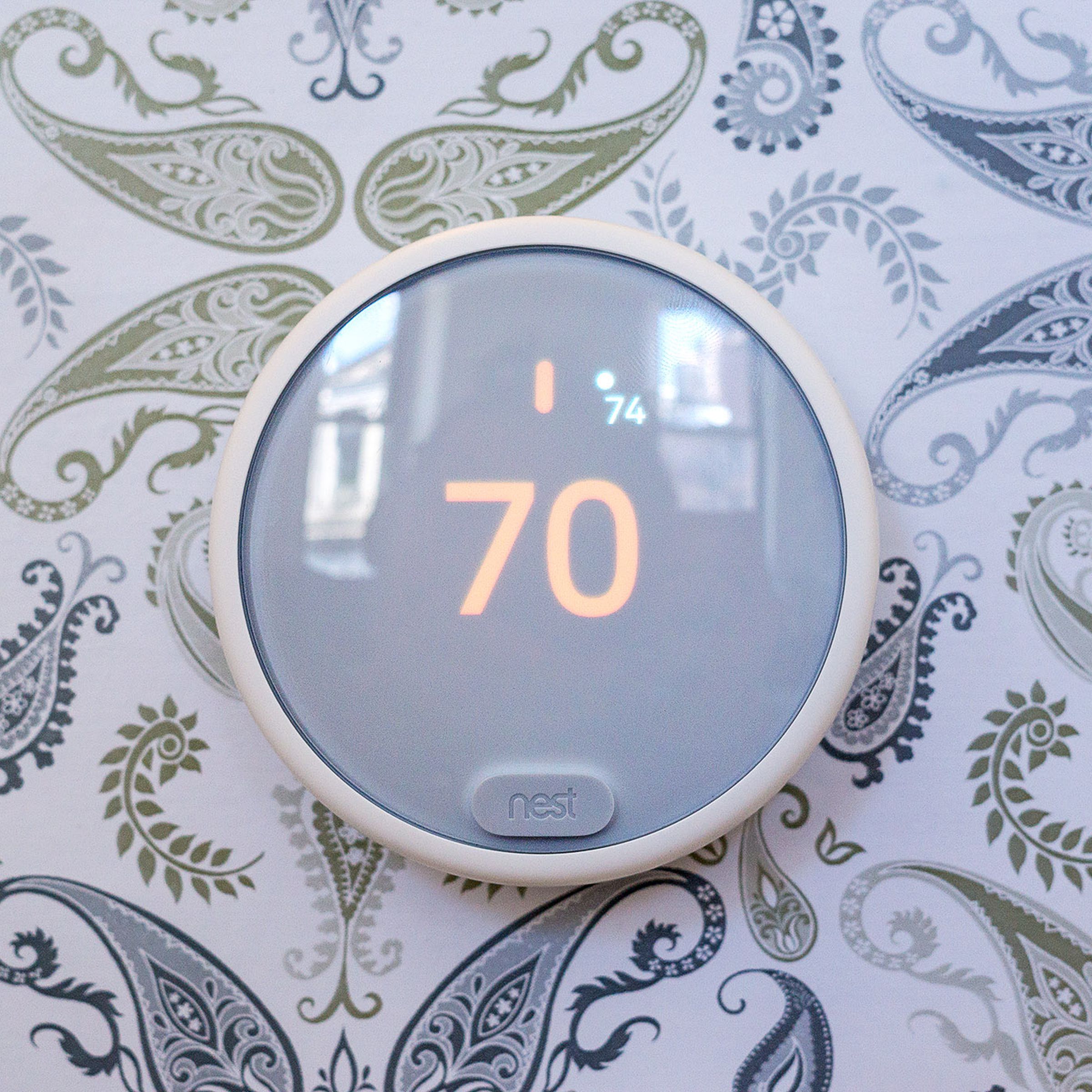 Nest E smart thermostat on wall with paisley wallpaper