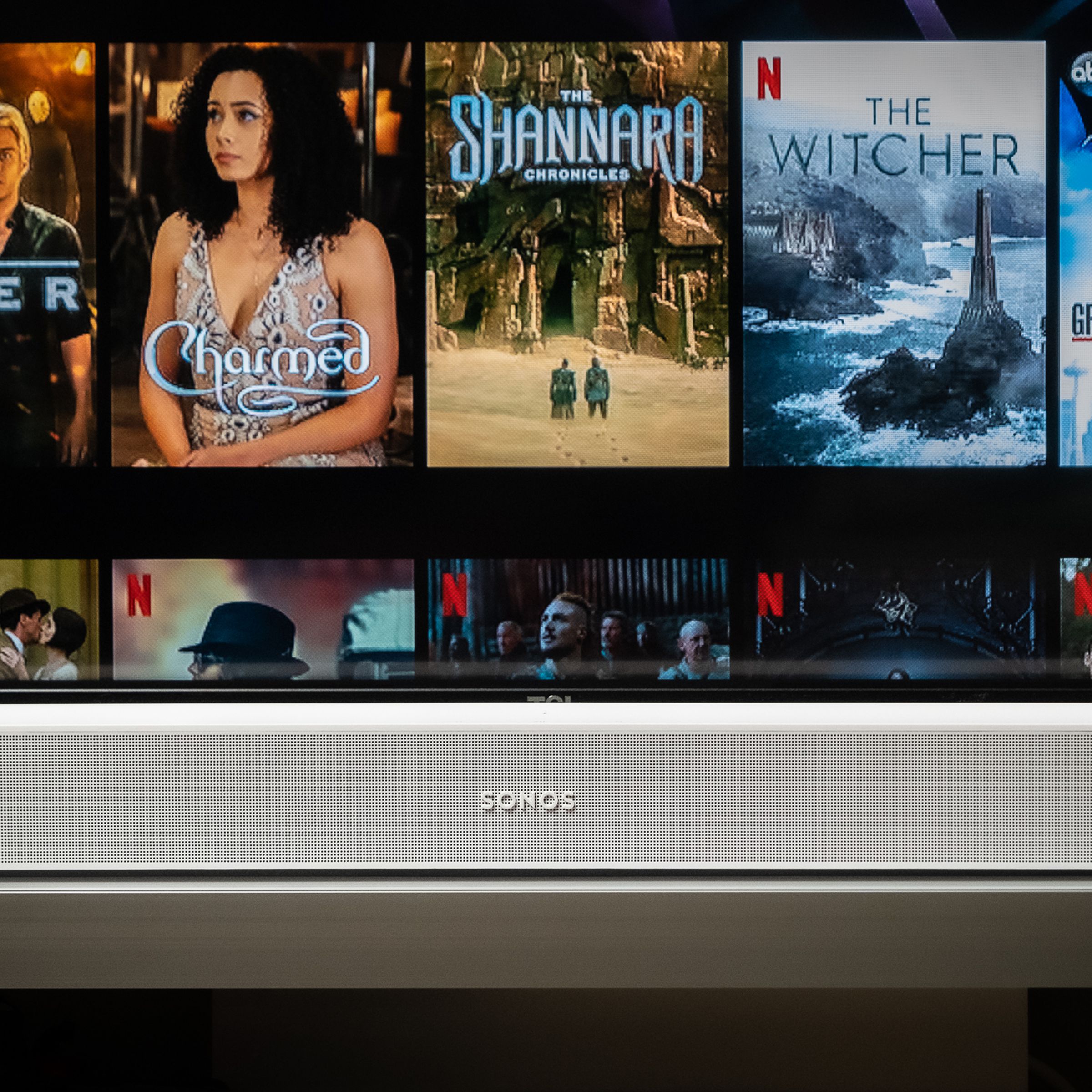 An image of the Sonos Beam soundbar with a TV screen in the background.