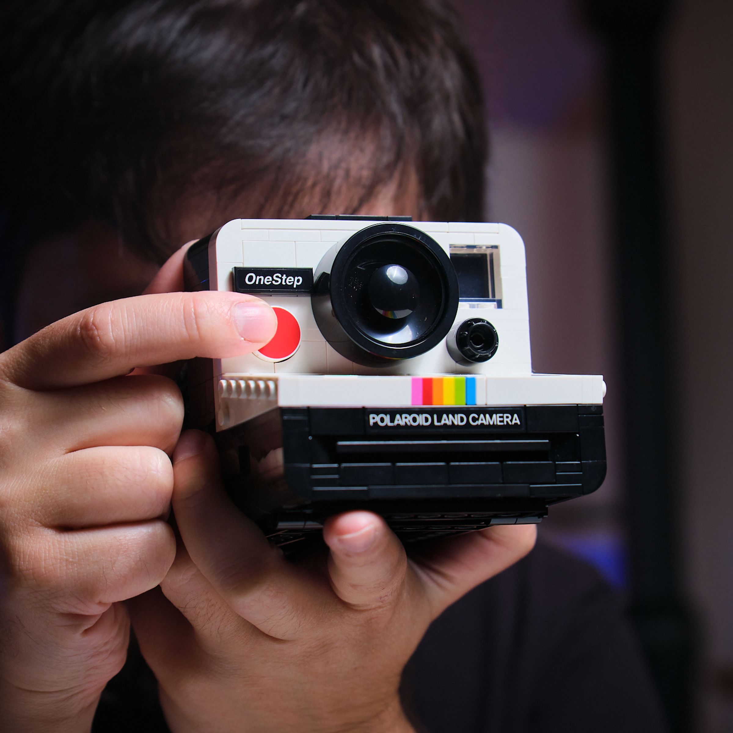 The Verge’s Sean Hollister holds up a Lego Polaroid camera.