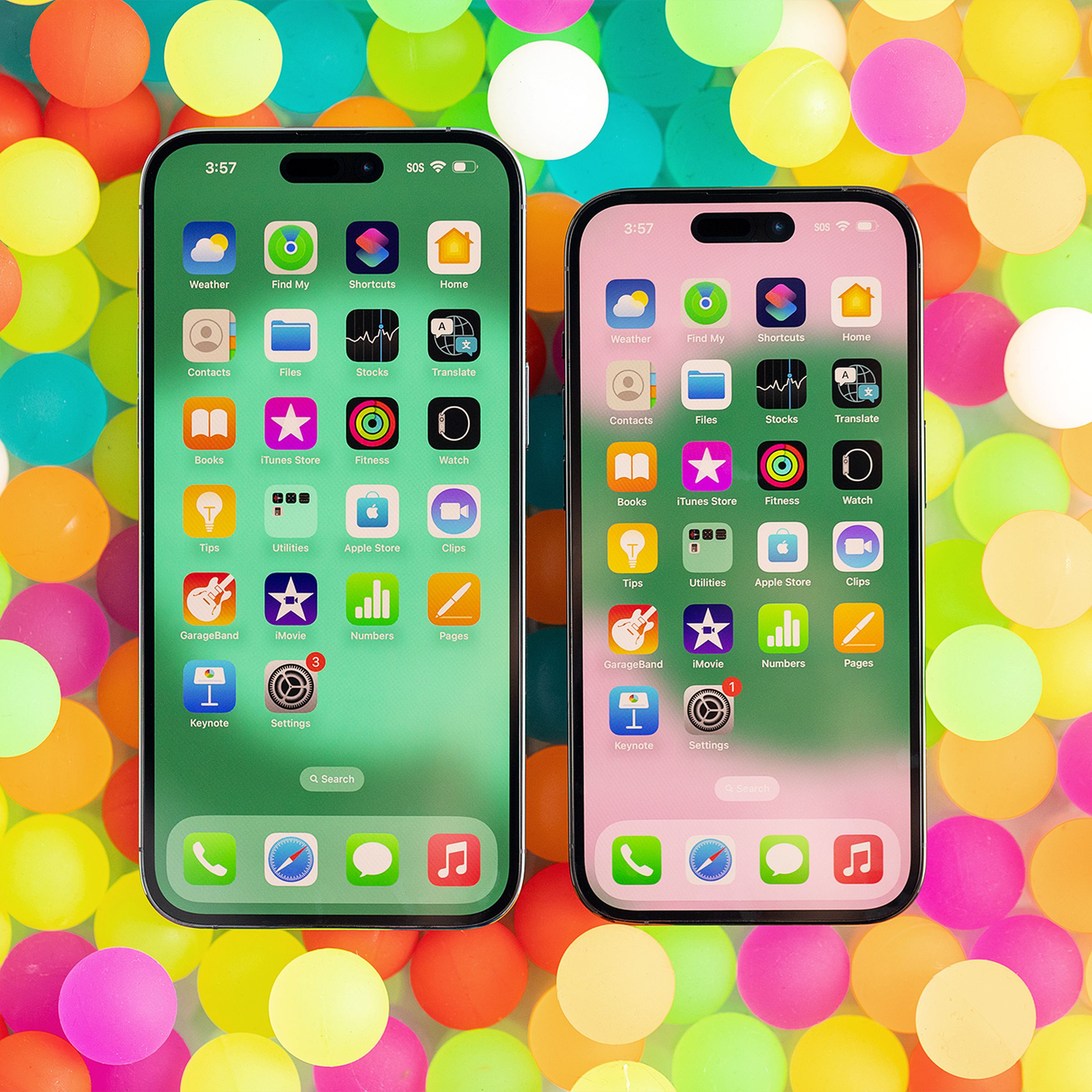 iPhone 14 Pro and 14 Pro Max on a backdrop of colorful bouncy balls.