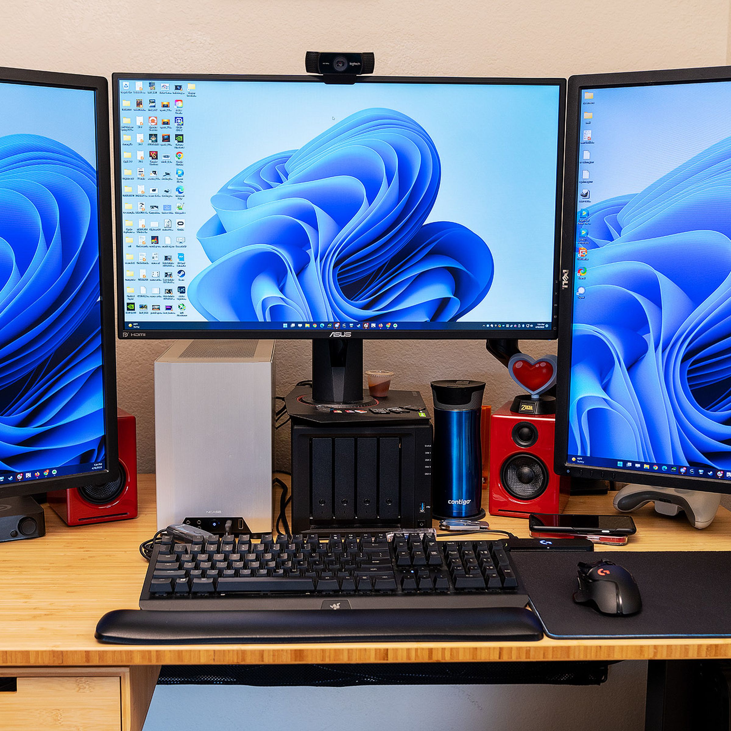 Three monitors sit atop a Fully Jarvis Bamboo Standing Desk.