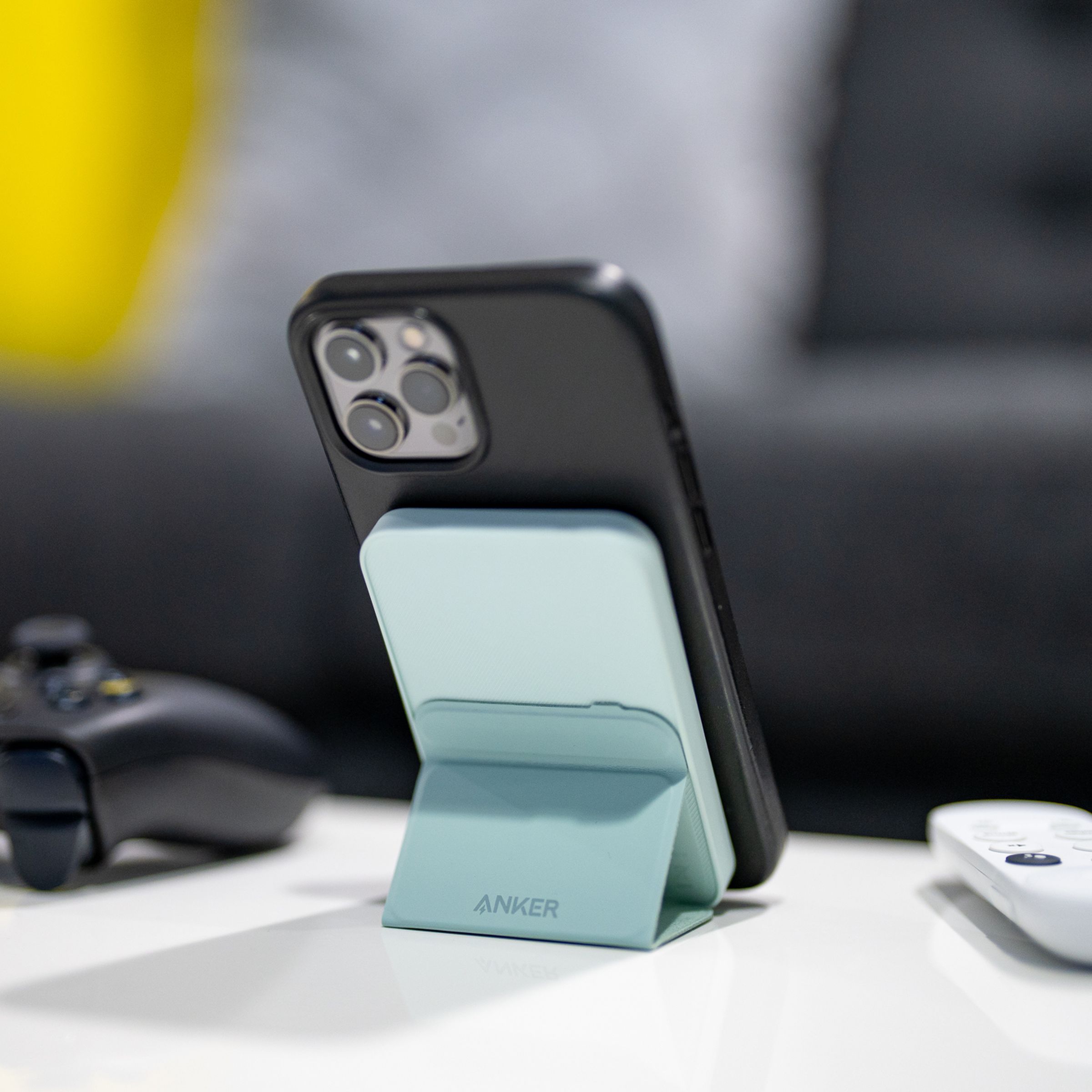 Anker’s 622 Magnetic Battery (MagGo) holding up an iPhone with its kickstand on a desk.
