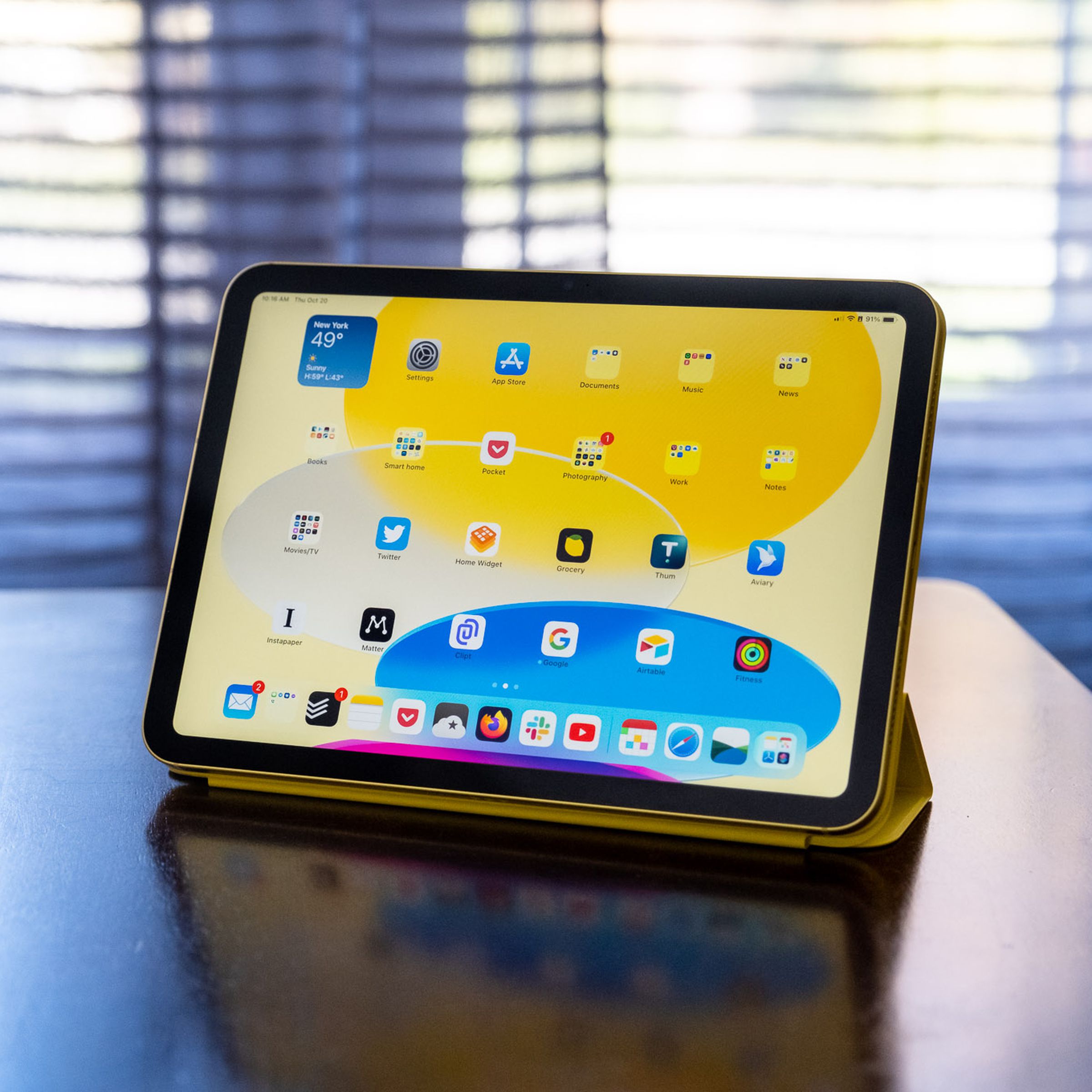 Um iPad de 10ª geração em um Apple Smart Folio em uma mesa de madeira.
