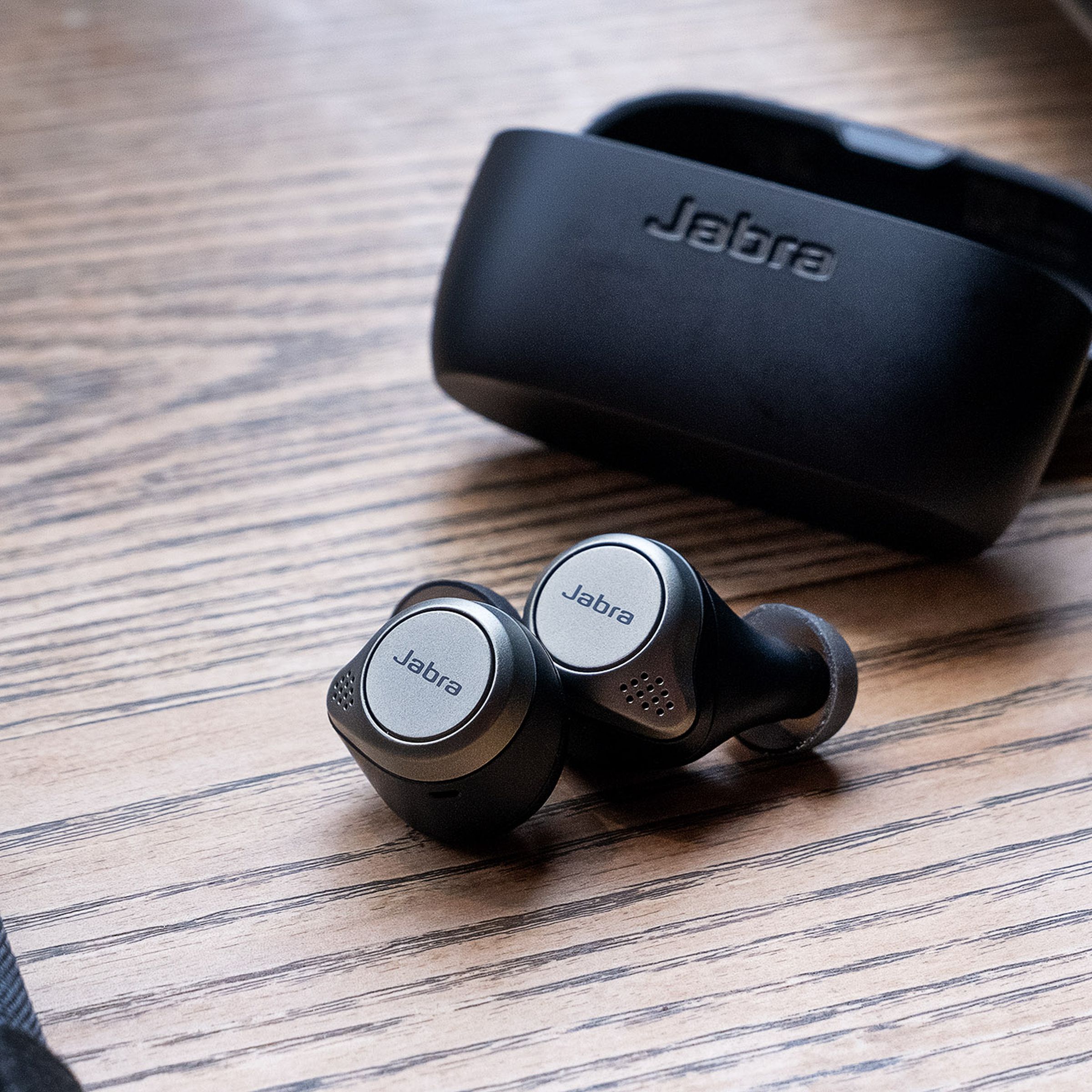 Jabra’s Elite 75t, the best wireless earbuds for multitasking, pictured on a table.