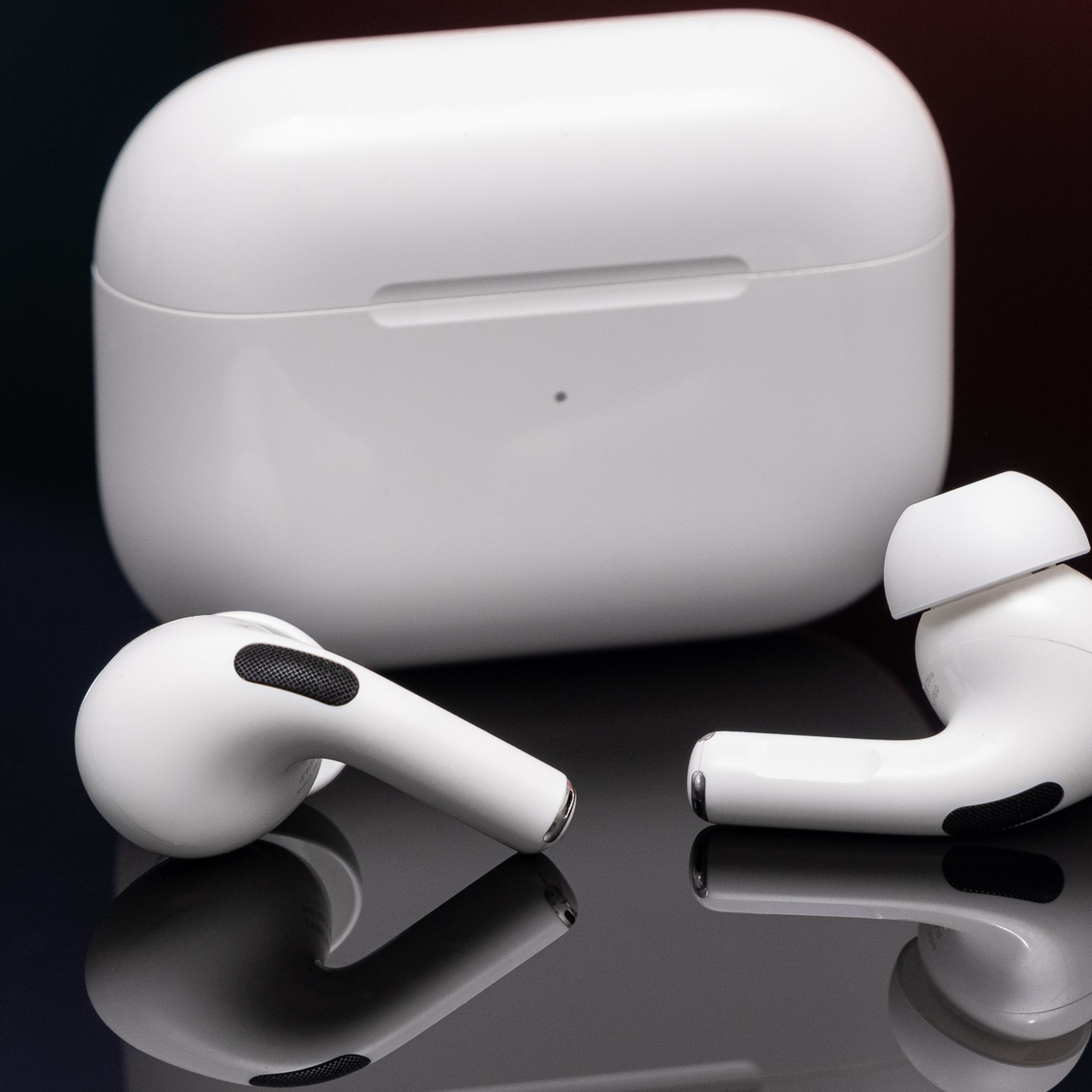Apple’s second-generation AirPods Pro photographed on a reflective black surface.