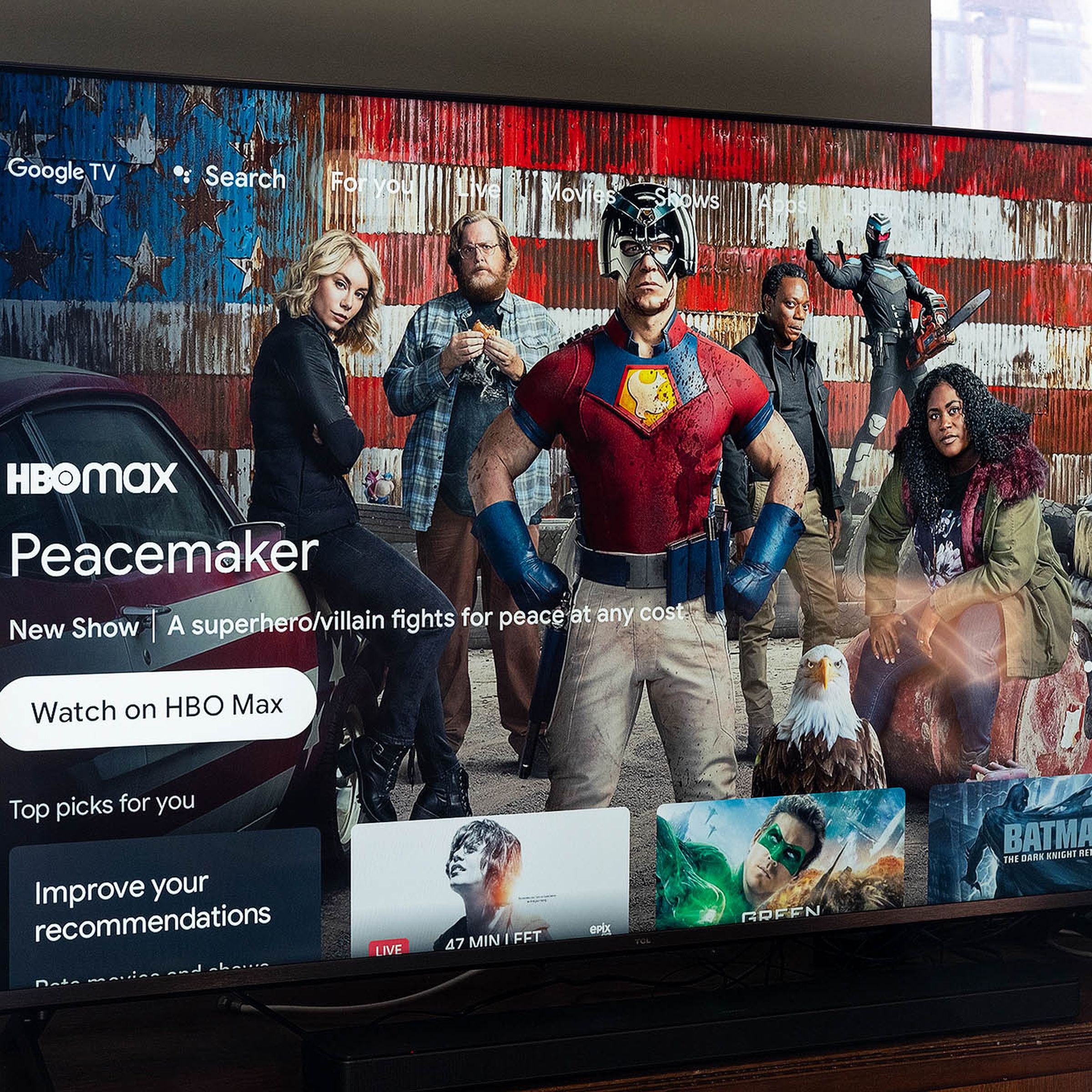 The 55-inch TCL 6-series R646 4K TV is on, displaying the Google TV software homescreen that’s filled with viewing recommendations.