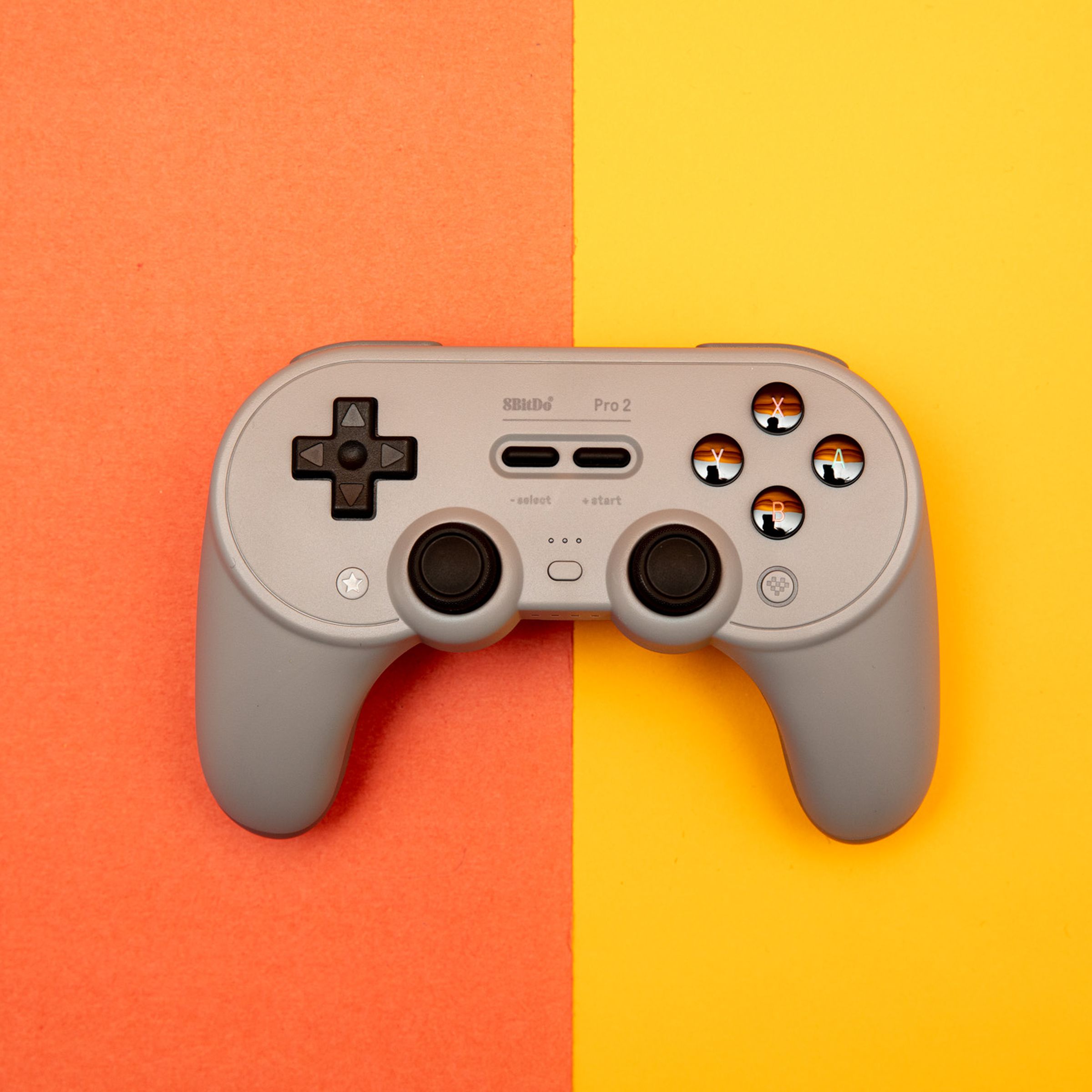 The 8BitDo Pro 2 wireless controller for the Nintendo Switch and other platforms sitting on a two-toned backdrop.
