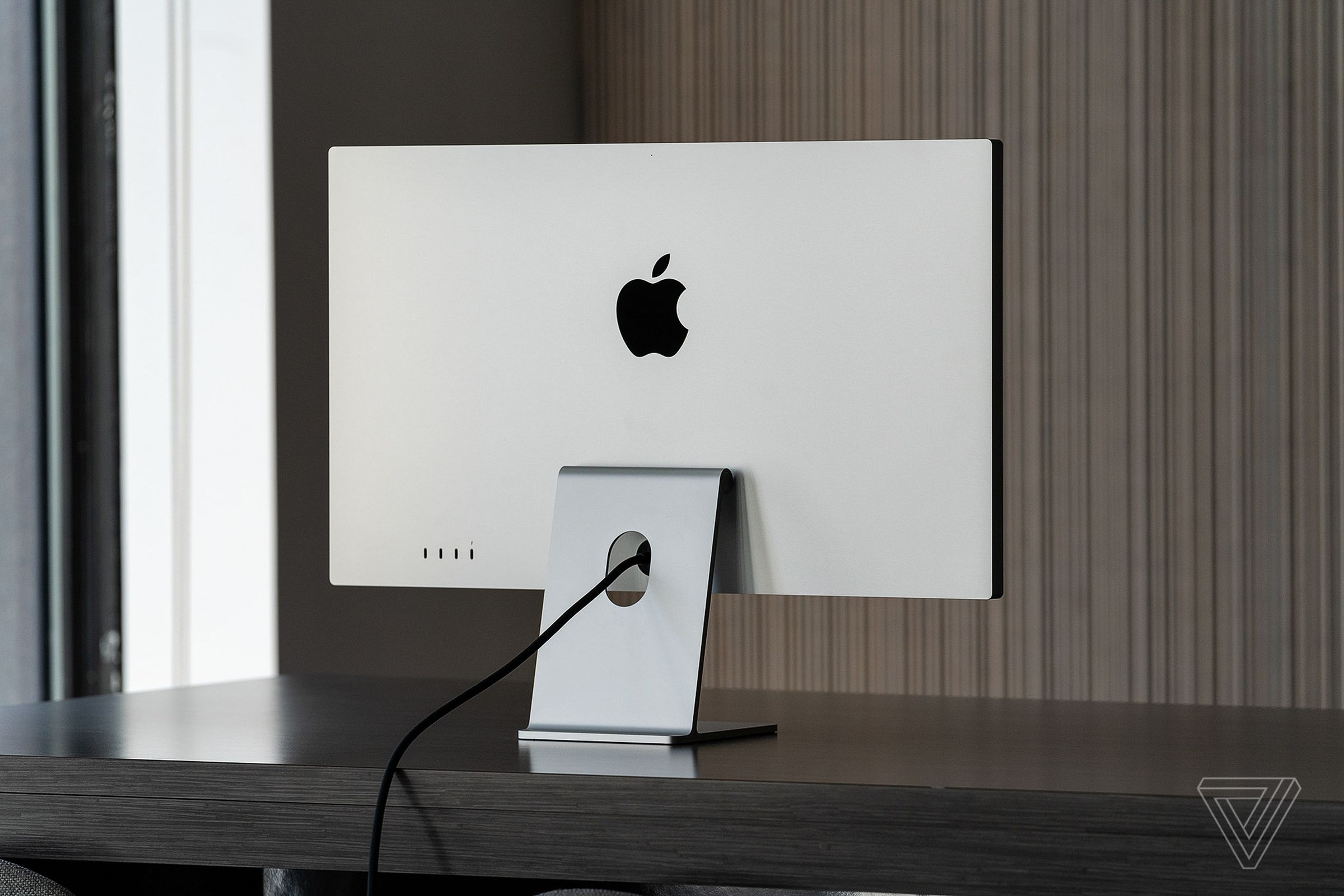 The back of the Apple Studio Display showing its standard tilt-adjustable stand.