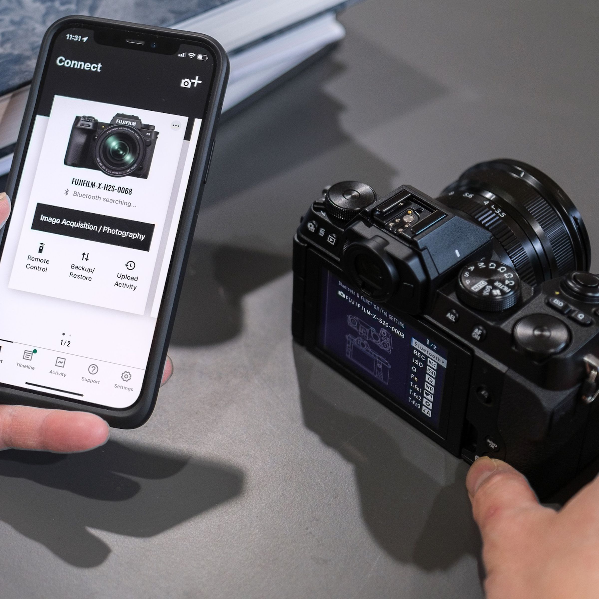 A photo of a Fujifilm camera beside the company’s new XApp mobile app.